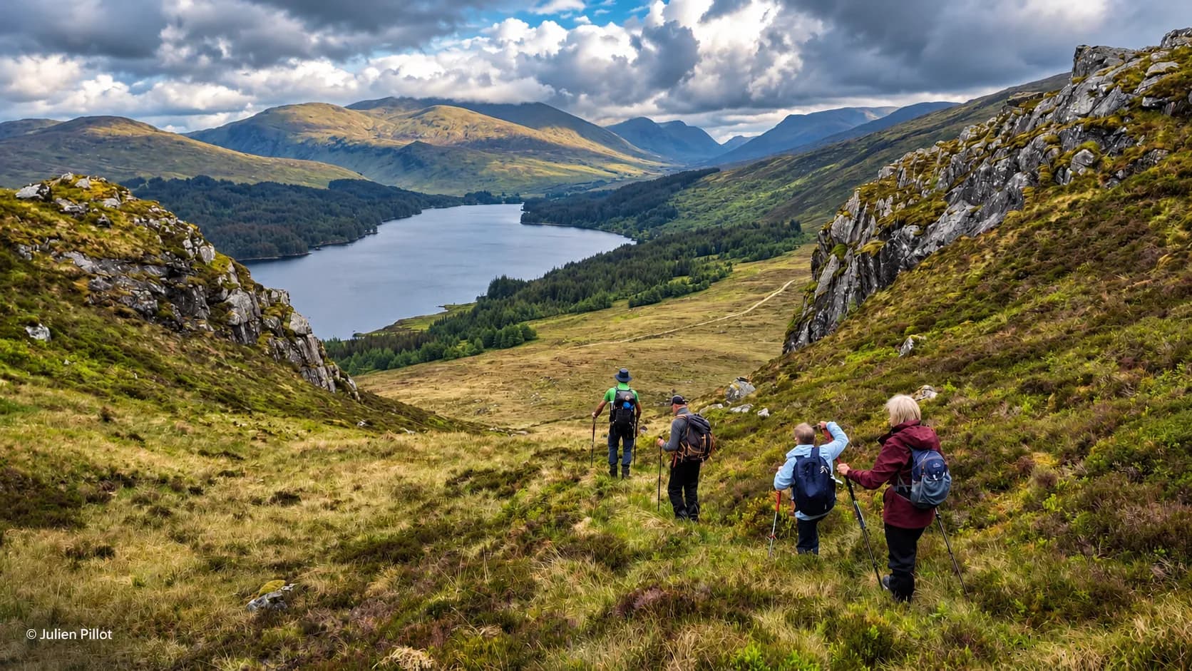 Een groep wandelaars verkent het heuvelachtige landschap van de Schotse Highlands, aan de oever van een loch.