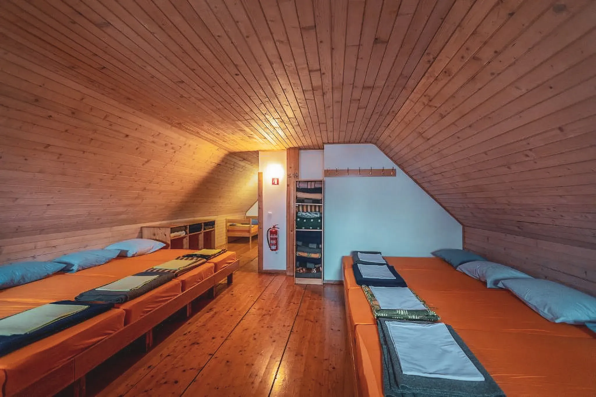 Chambre chaleureuse en bois avec lits accueillants, idéale pour se reposer après une aventure alpine.