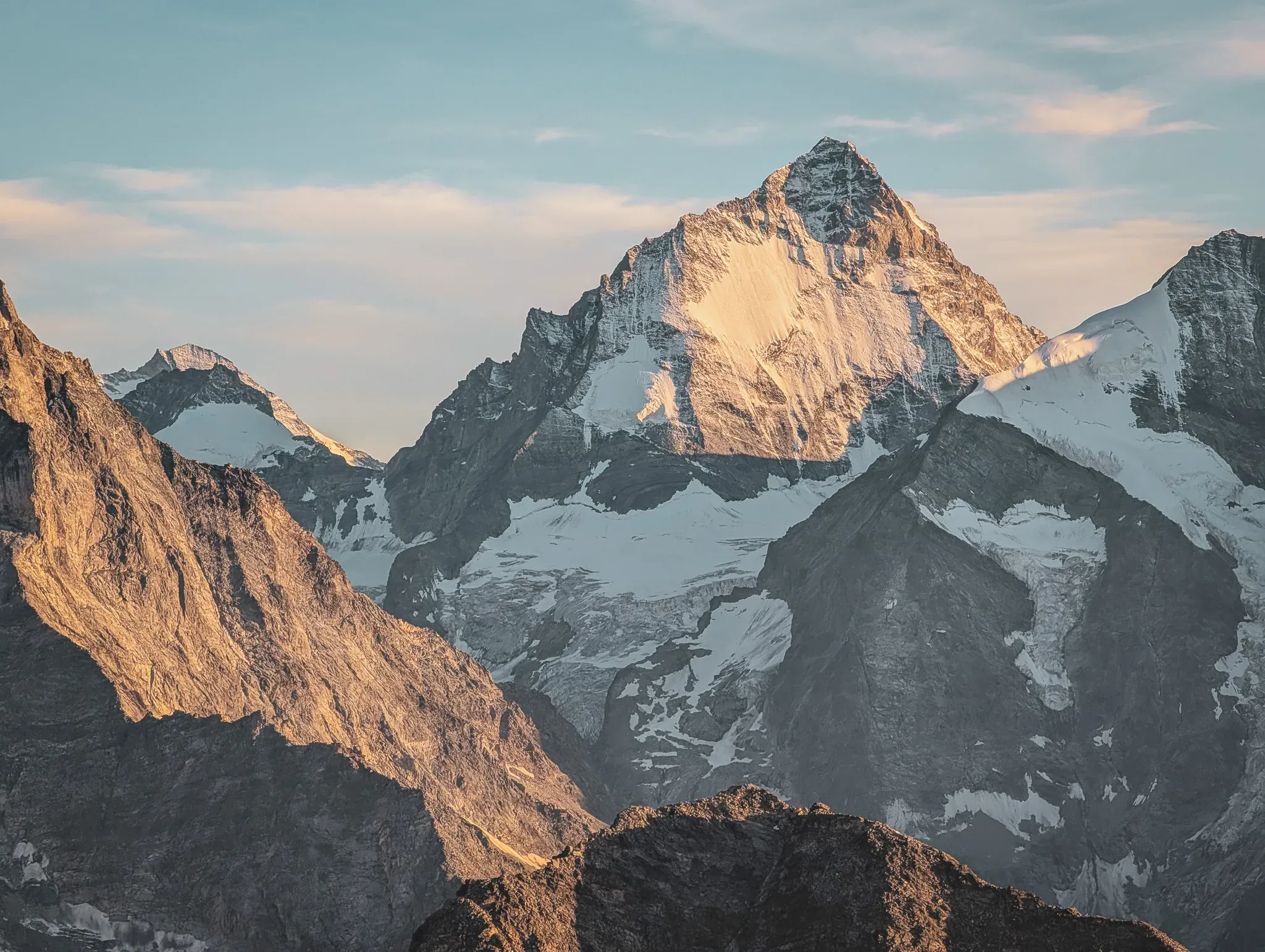A majestic mountain peak, lit up by the sun, promising an unforgettable alpine adventure.