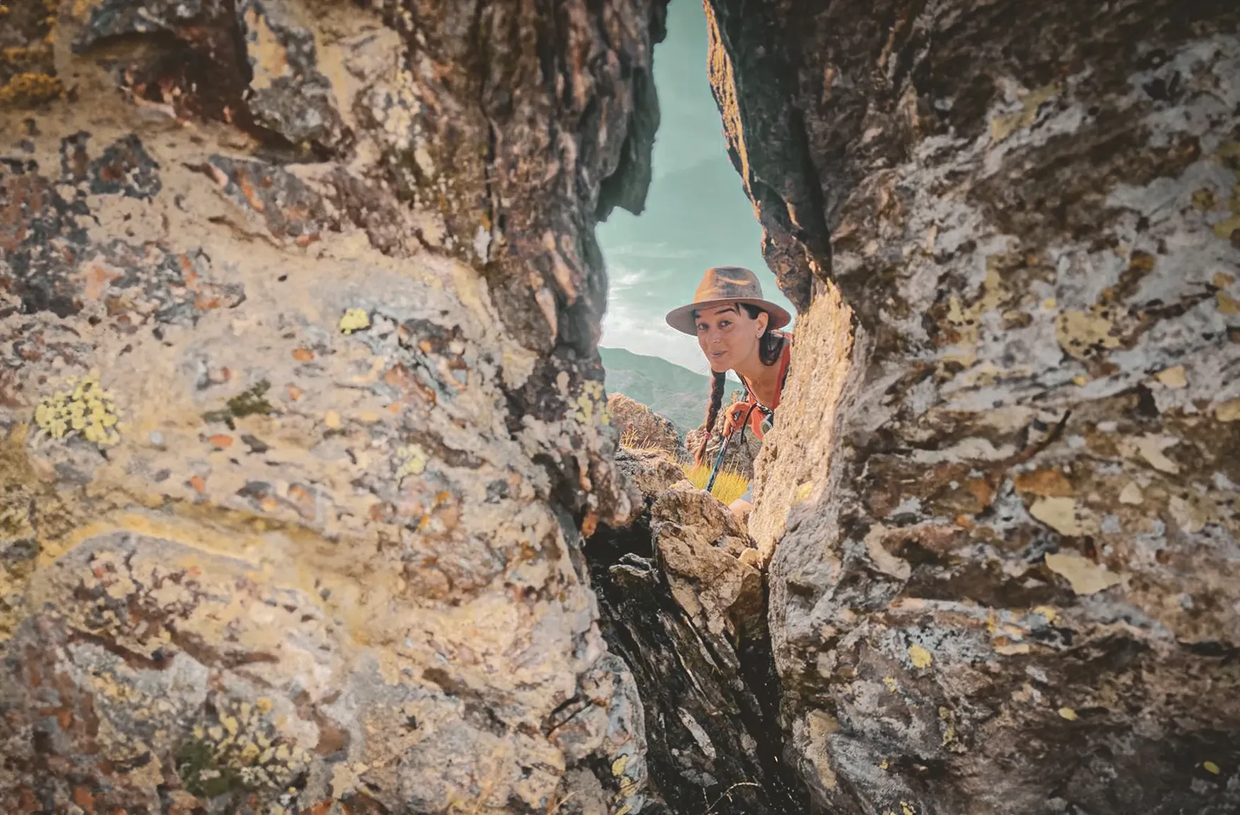 Een nieuwsgierige wandelaar tuurt door de rotsen, omringd door de wilde landschappen van de Cevennen.