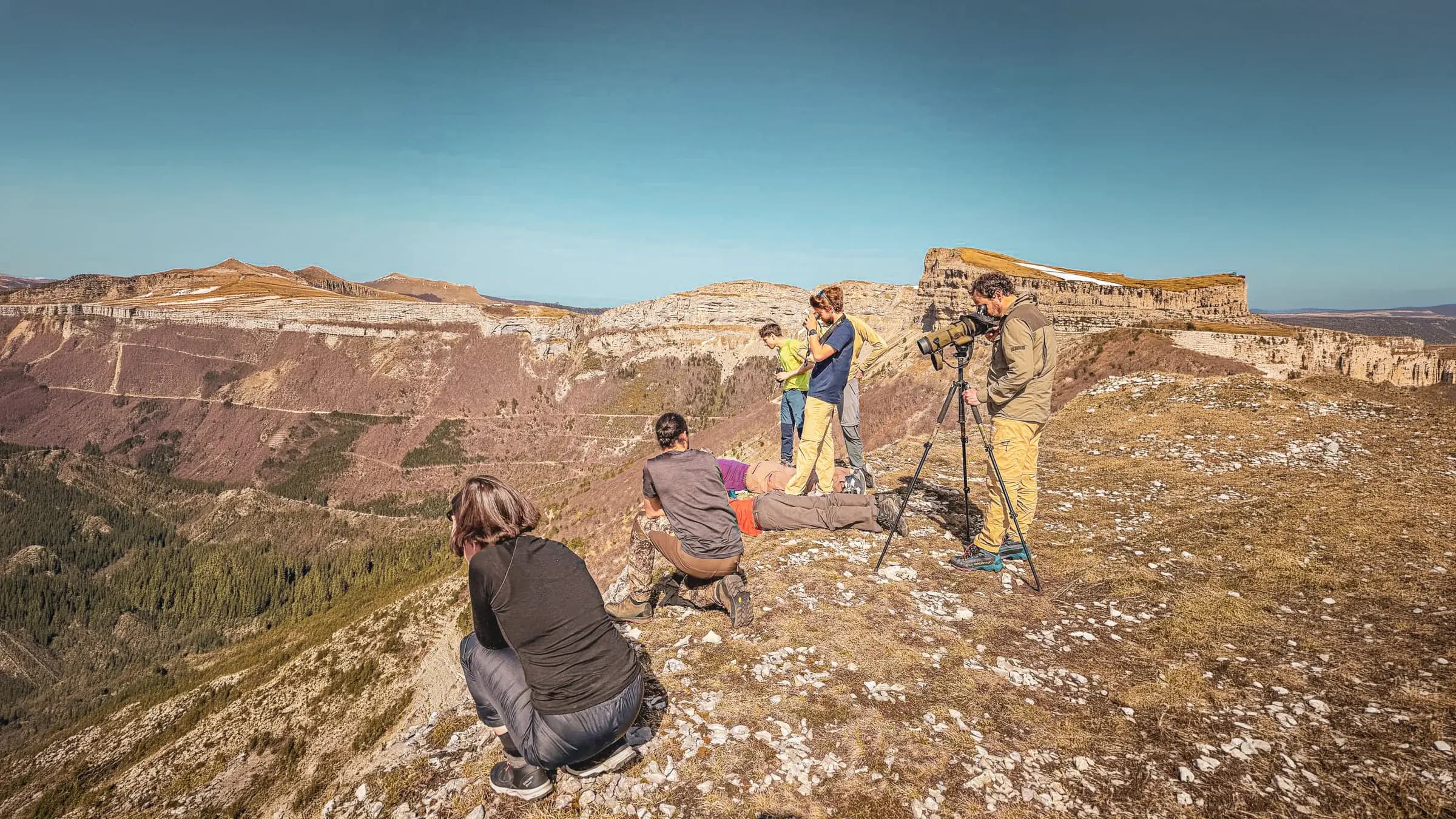 Een groep wandelaars bekijkt een adembenemend landschap in de Vercors, onder een heldere hemel.