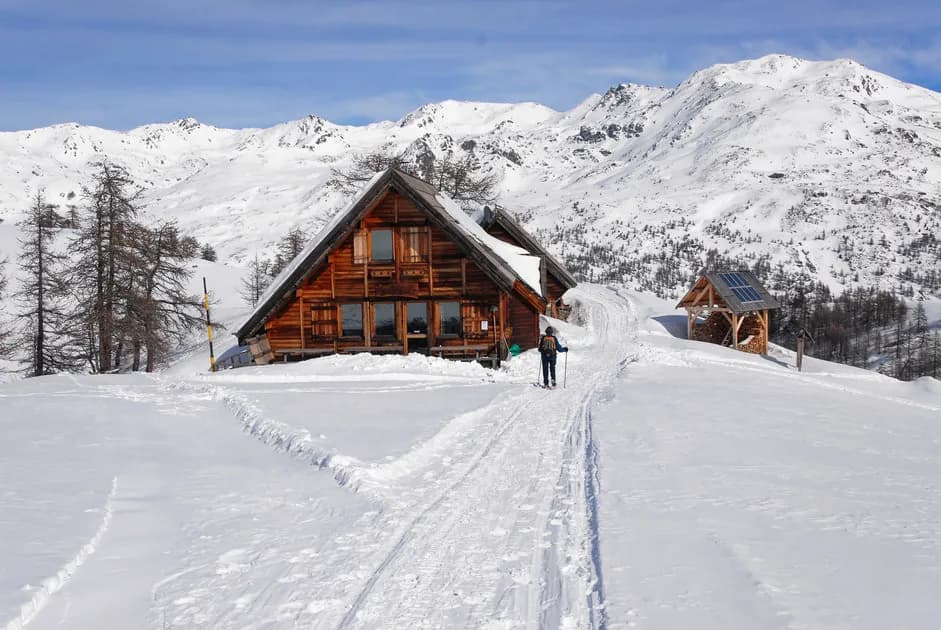 Refuge en bois au cœur des montagnes enneigées, parfait pour une aventure hivernale.