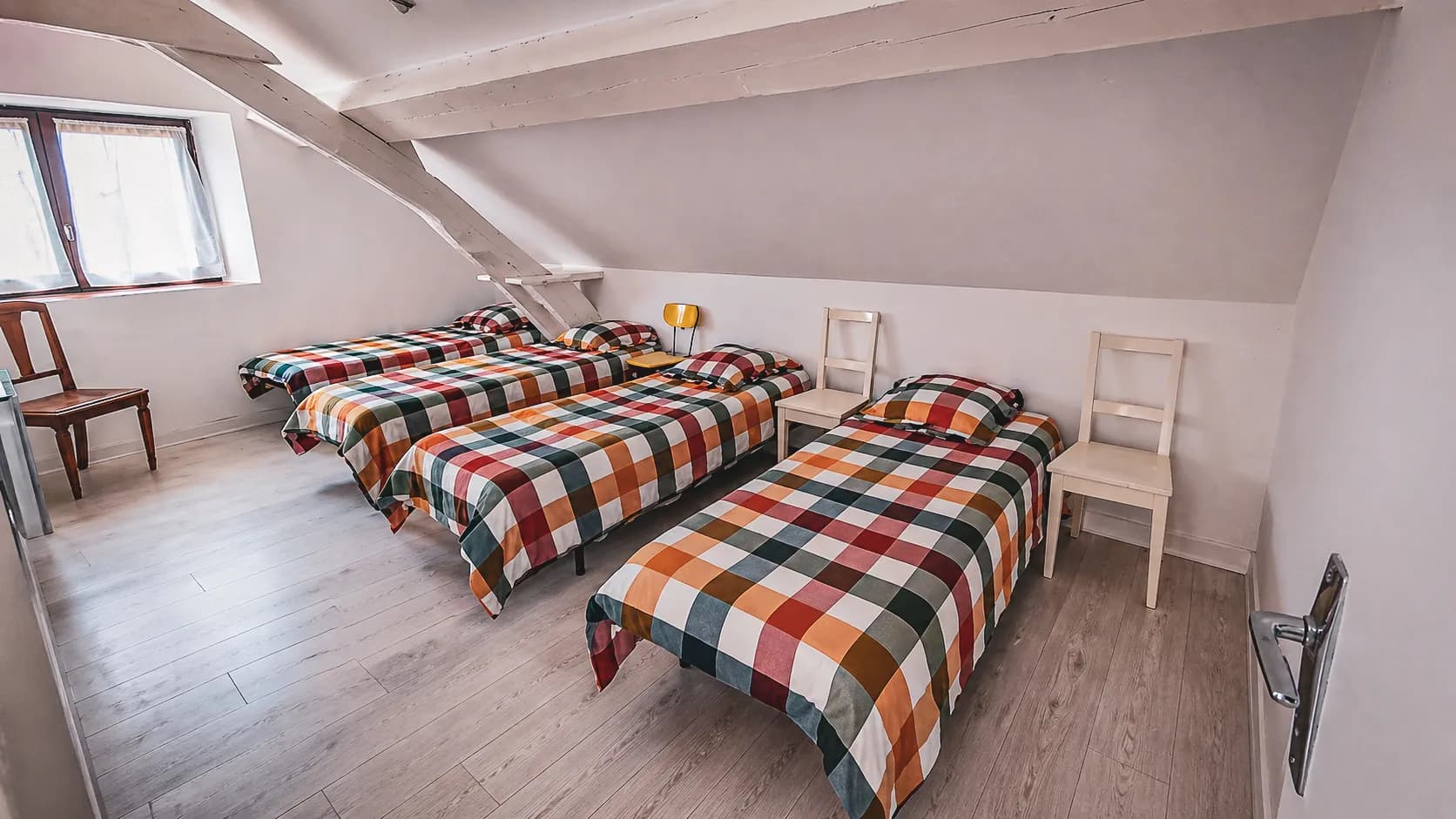 Chambres accueillantes avec lits à carreaux colorés, parfaites pour un séjour dans les Hauts Plateaux.