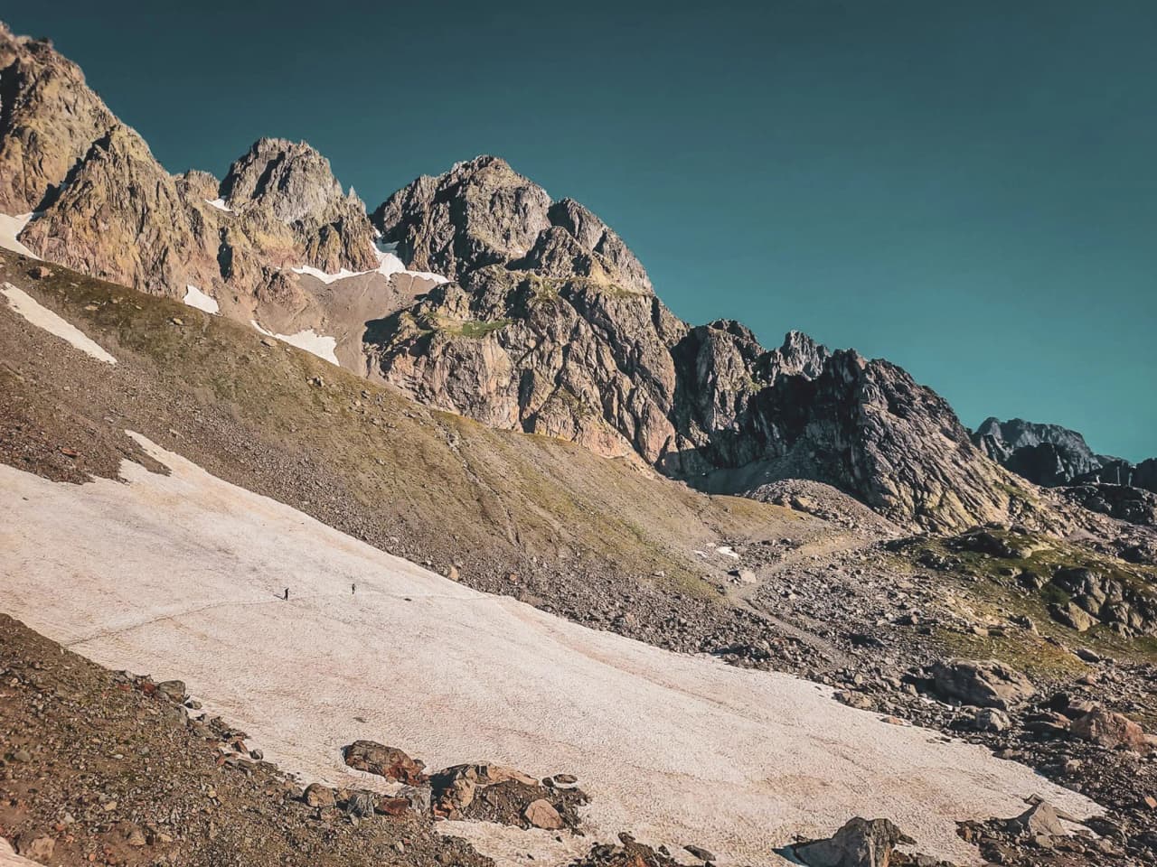 Two climbers move across a glacier with the majestic Chamonix mountains in the background.