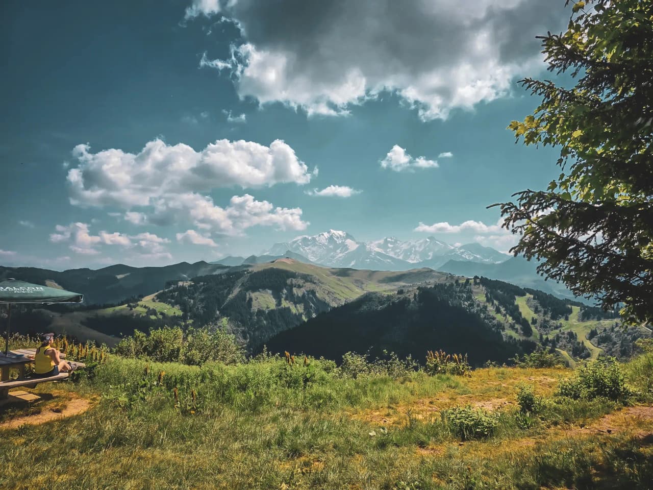 Panoramic view of the Val d'Arly ridges, with Mont Blanc in the background and lush green landscapes.
