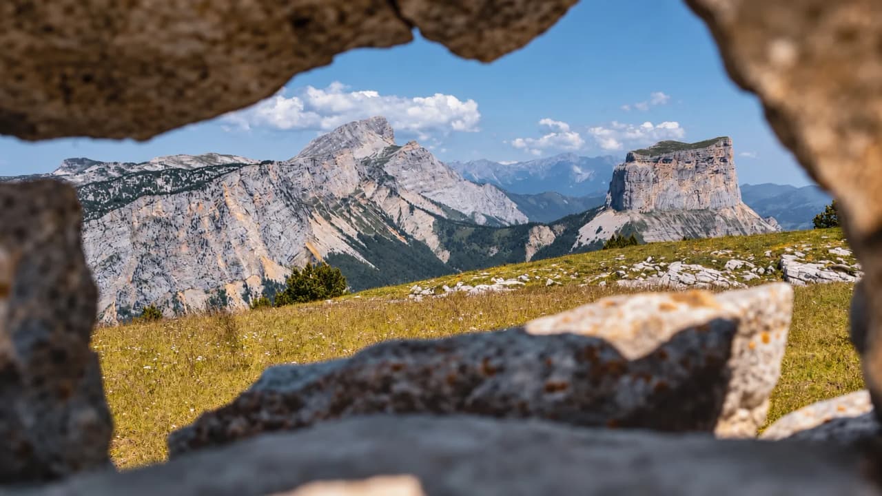 Panoramisch uitzicht op de Hoge Vercors-plateaus, met majestueuze bergen en een stralend blauwe lucht.