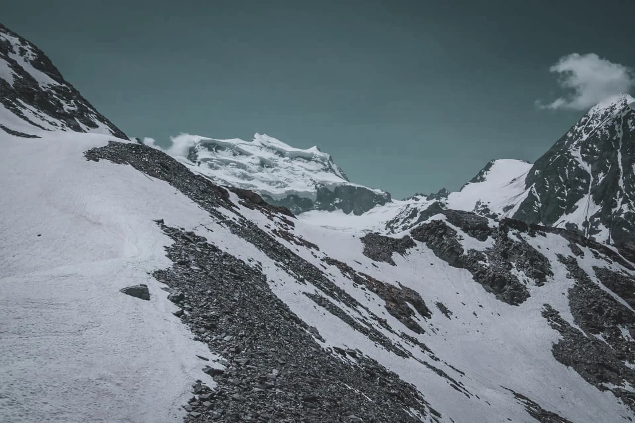 Majestic Alpine scenery, glistening glaciers and snow-capped peaks rising beneath a blue sky.