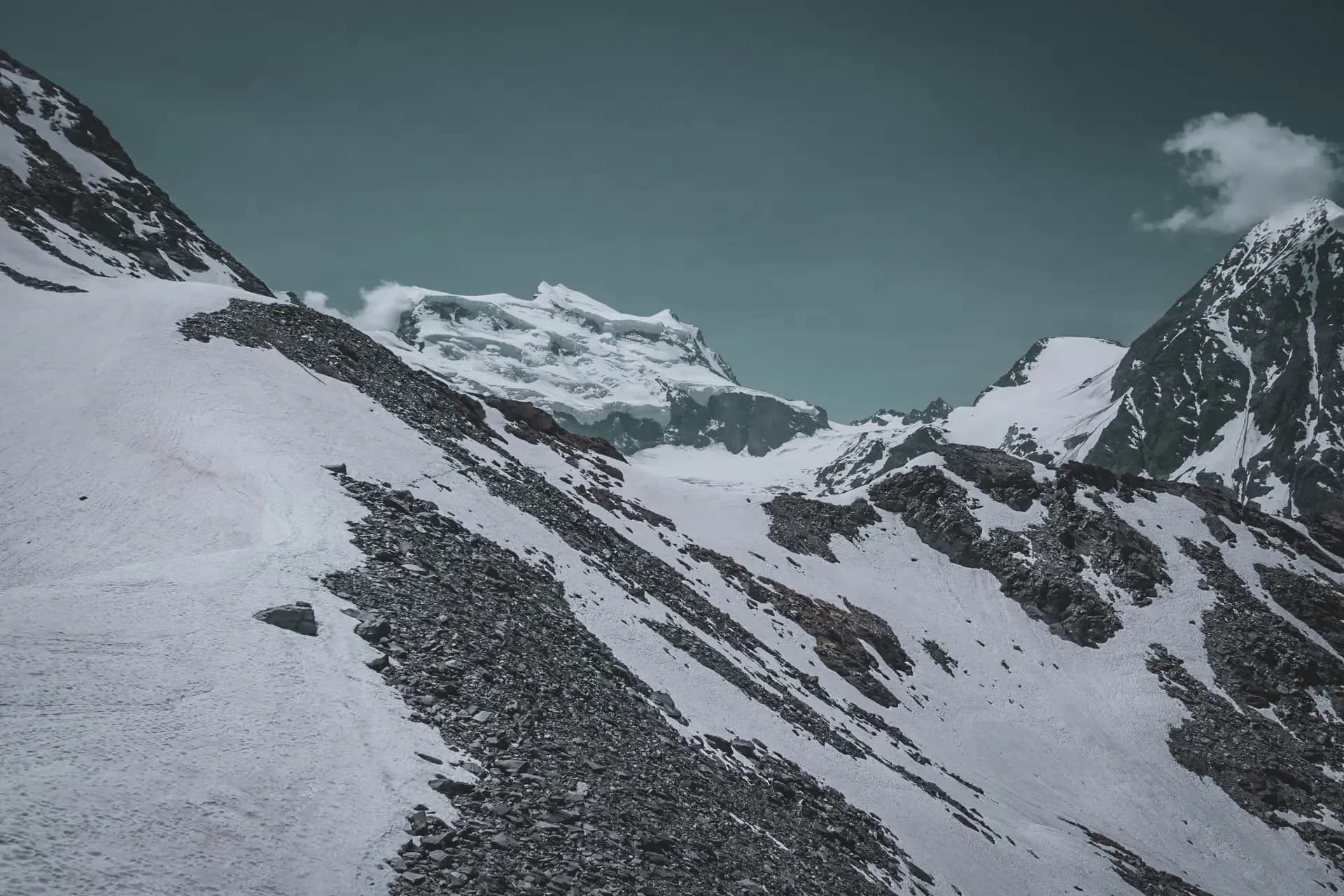 Majestic Alpine scenery, glistening glaciers and snow-capped peaks rising beneath a blue sky.