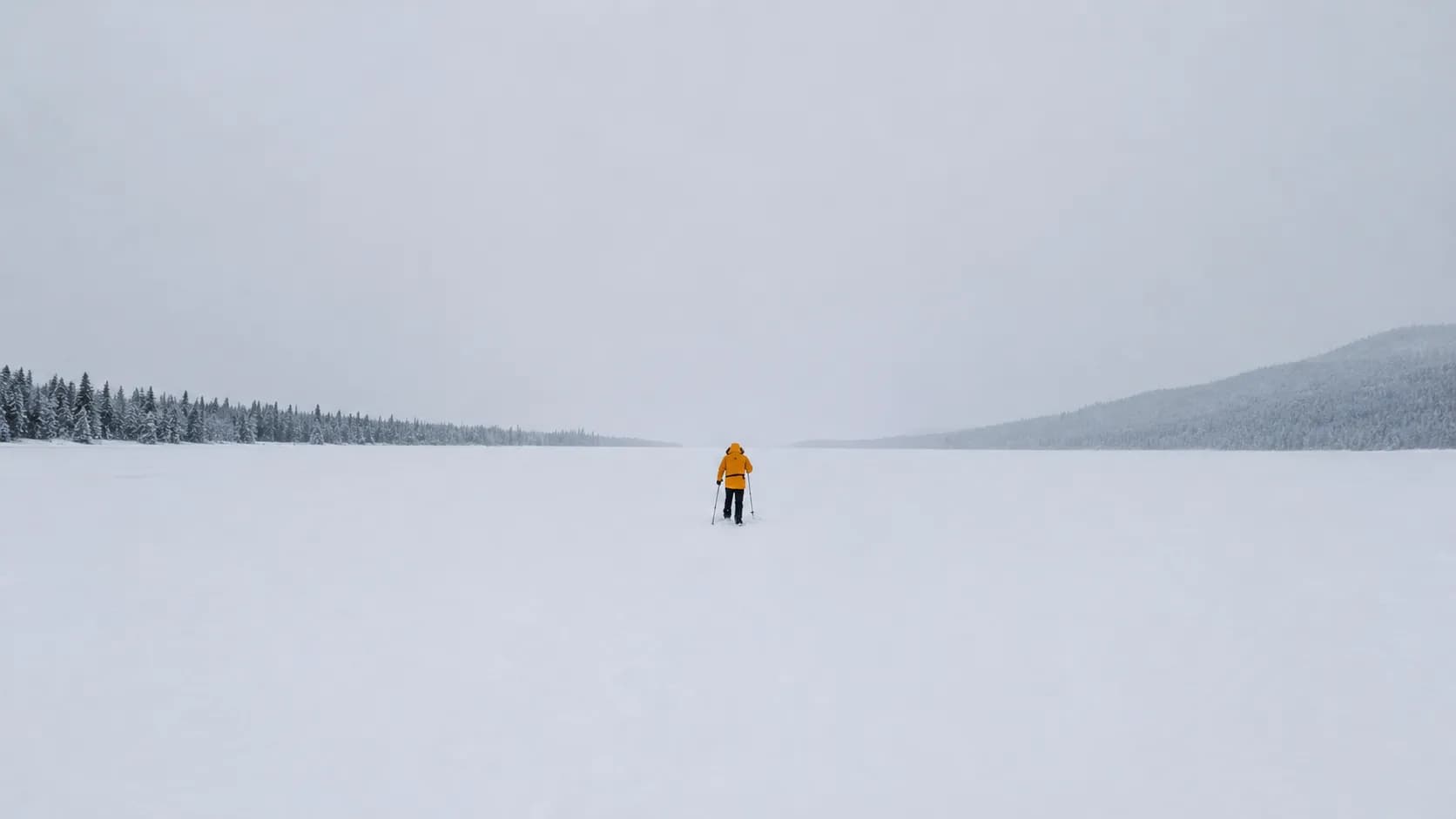 Een avonturier in een gele jumpsuit doorkruist een besneeuwd landschap, omringd door majestueuze dennenbomen.
