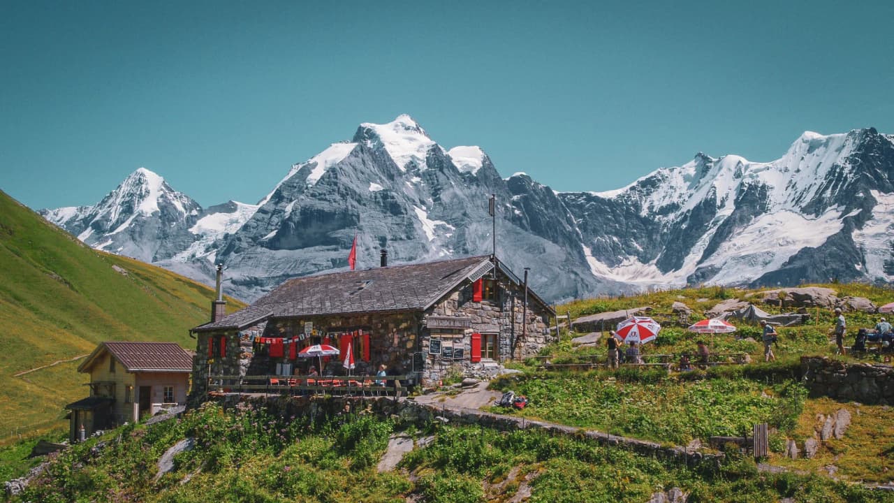 Refuge pittoresque au cœur des Alpes, entouré de sommets majestueux et de prairies verdoyantes.