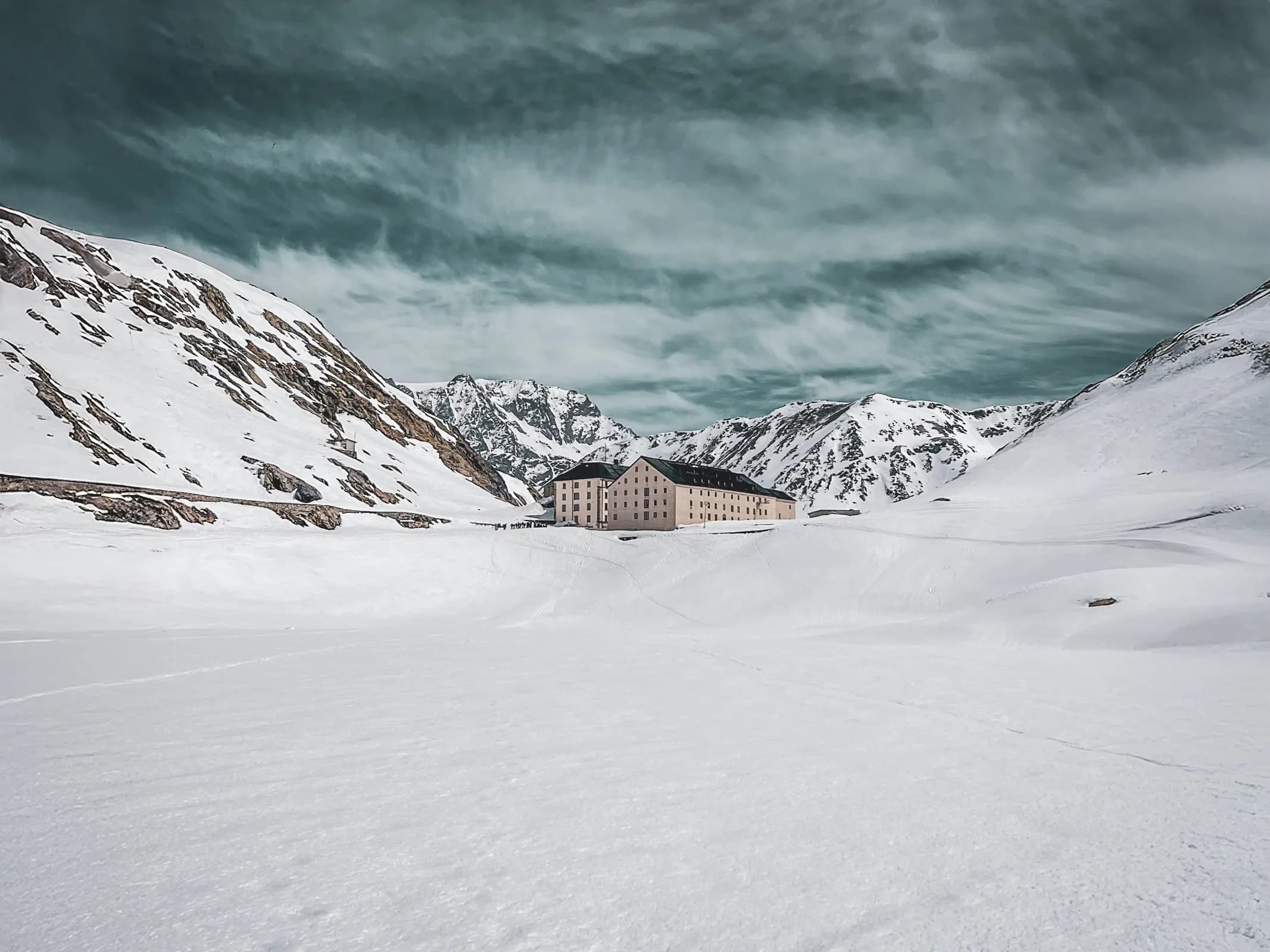 Un paysage alpin spectaculaire, neige immaculée, montagnes majestueuses et un refuge accueillant.