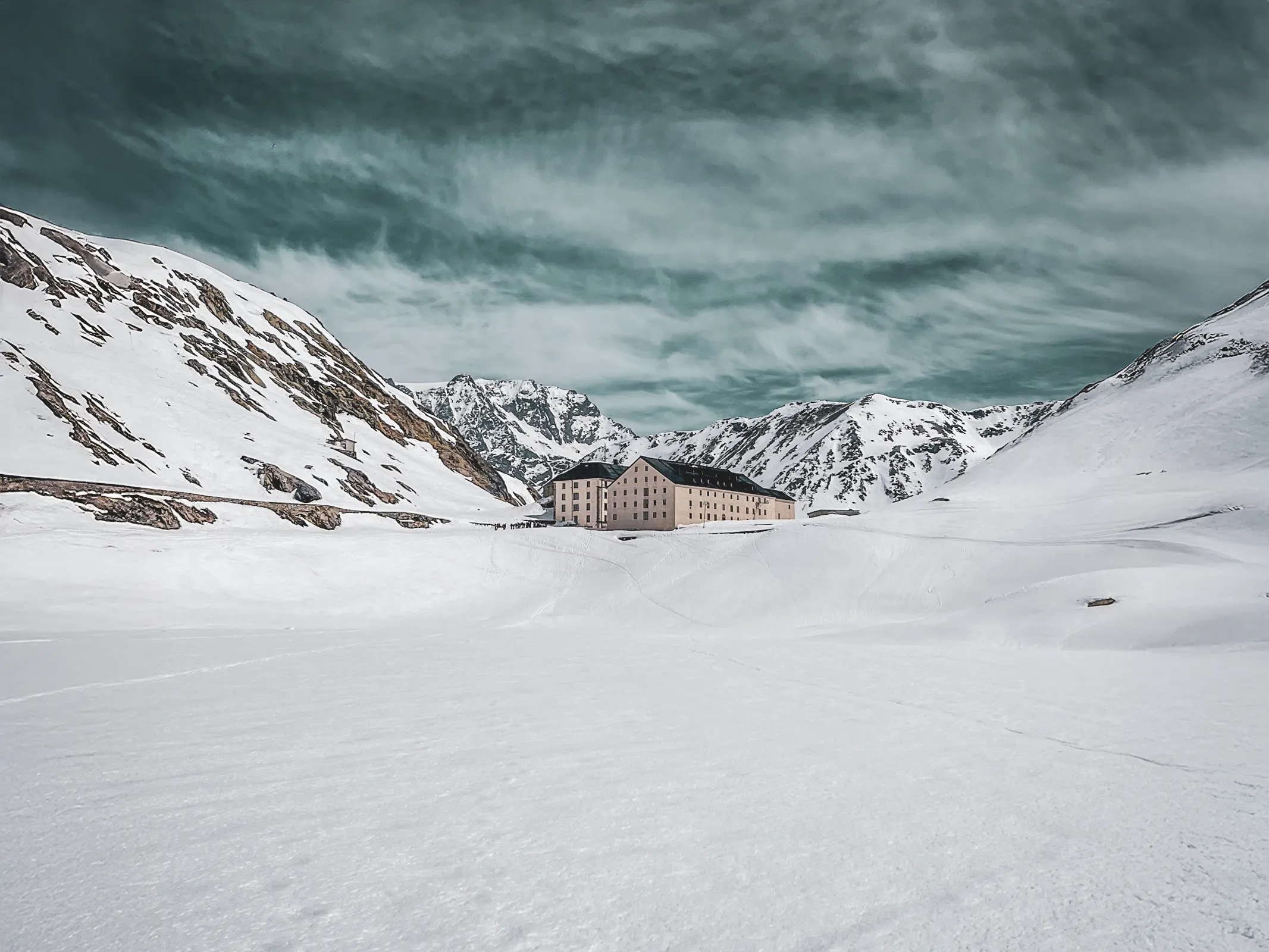 Un paysage alpin spectaculaire, neige immaculée, montagnes majestueuses et un refuge accueillant.