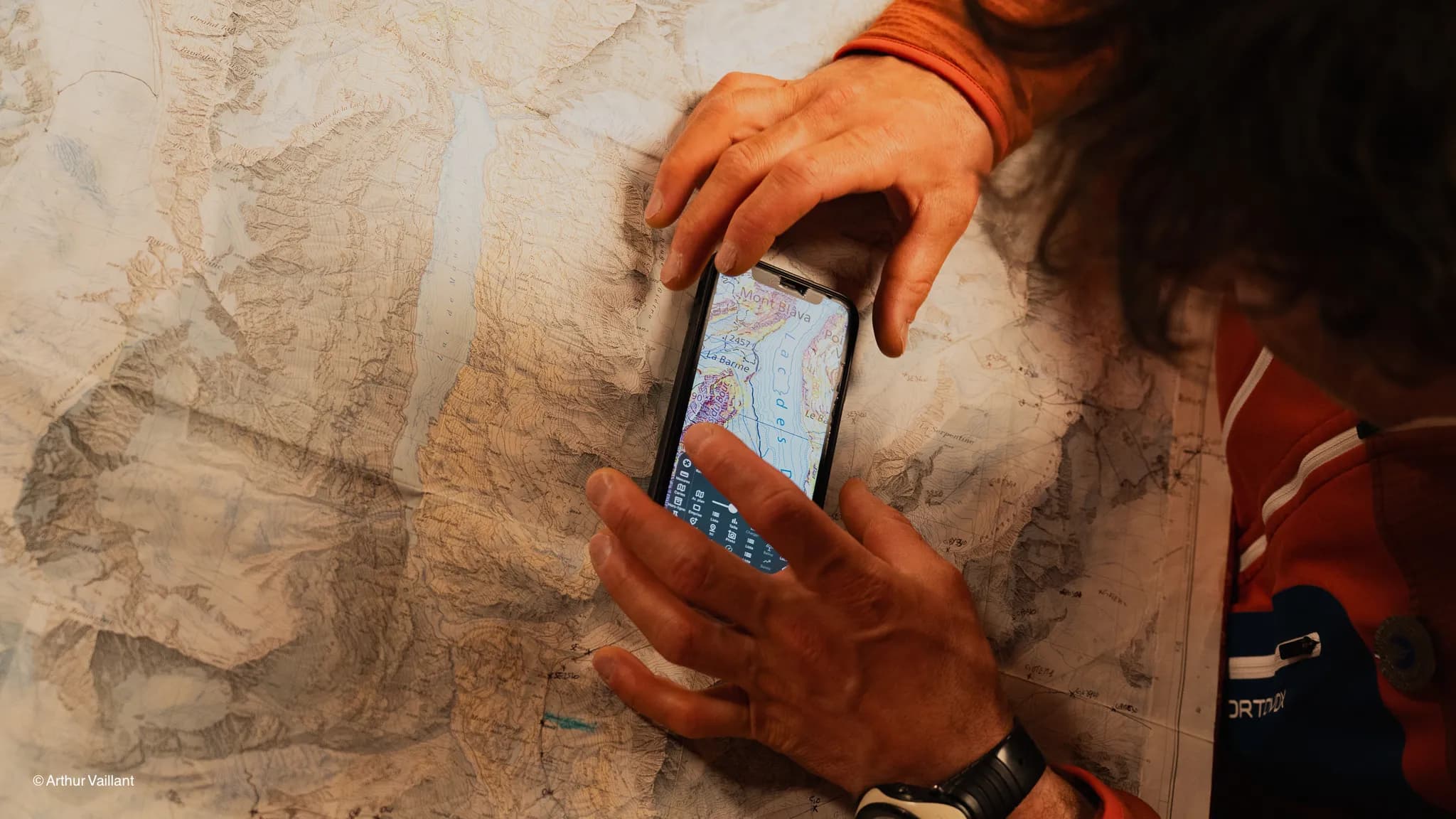 A skier studies a map against a backdrop of Alpine glaciers, preparing for an epic adventure.