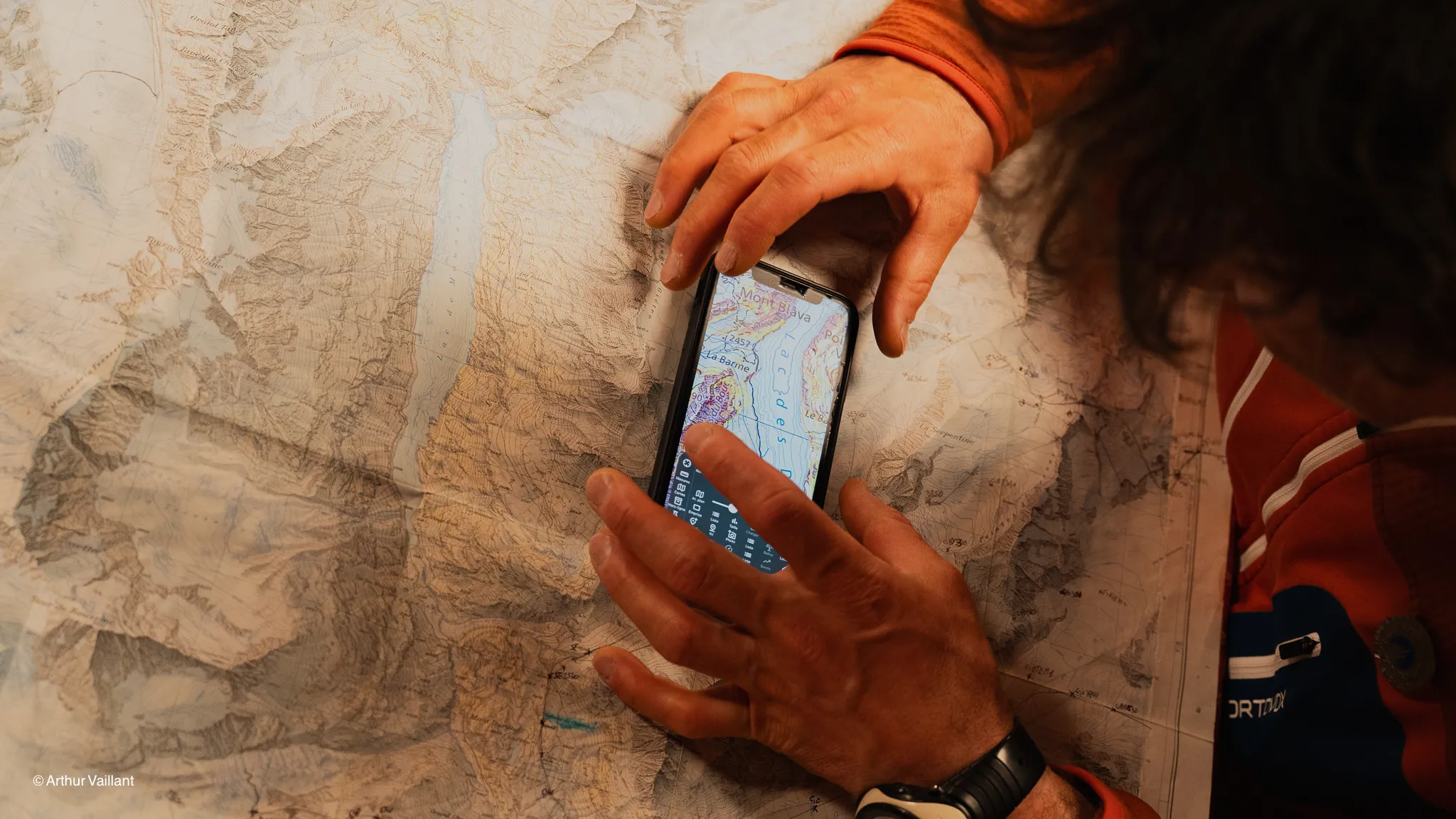 A skier studies a map against a backdrop of Alpine glaciers, preparing for an epic adventure.