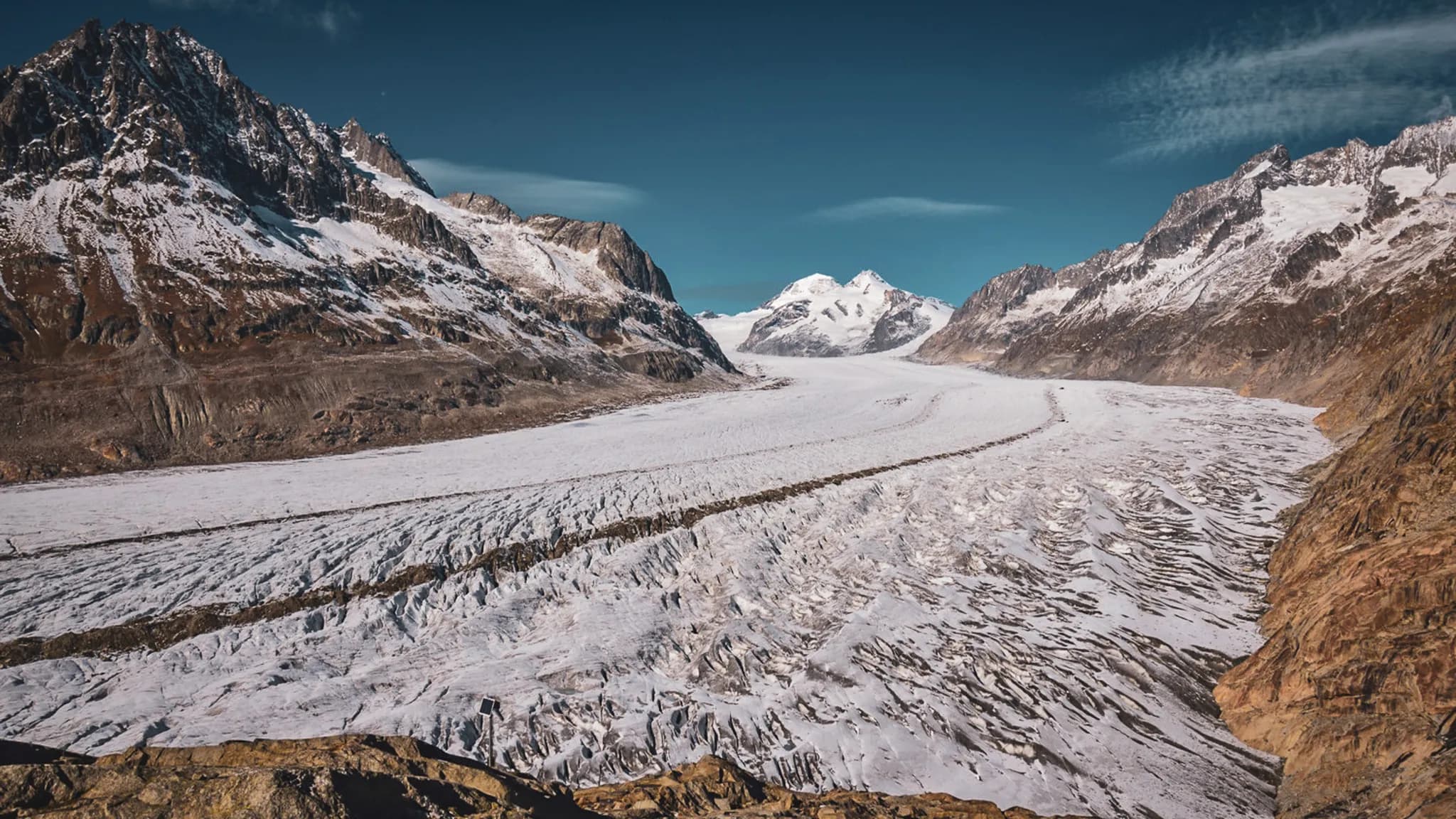 Panorama spectaculaire du glacier d'Aletsch, entre montagnes majestueuses et ciel bleu.