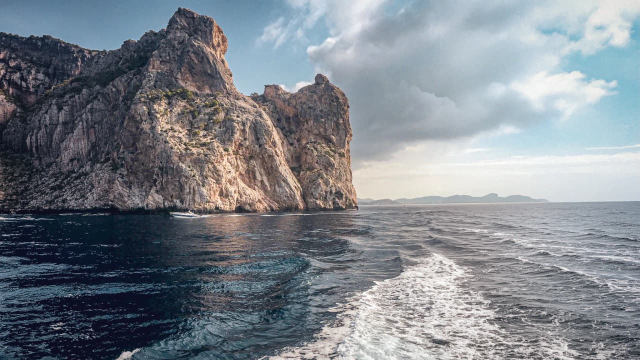 A majestic cliff overlooking turquoise waters, inviting you to set off on a sailing adventure.