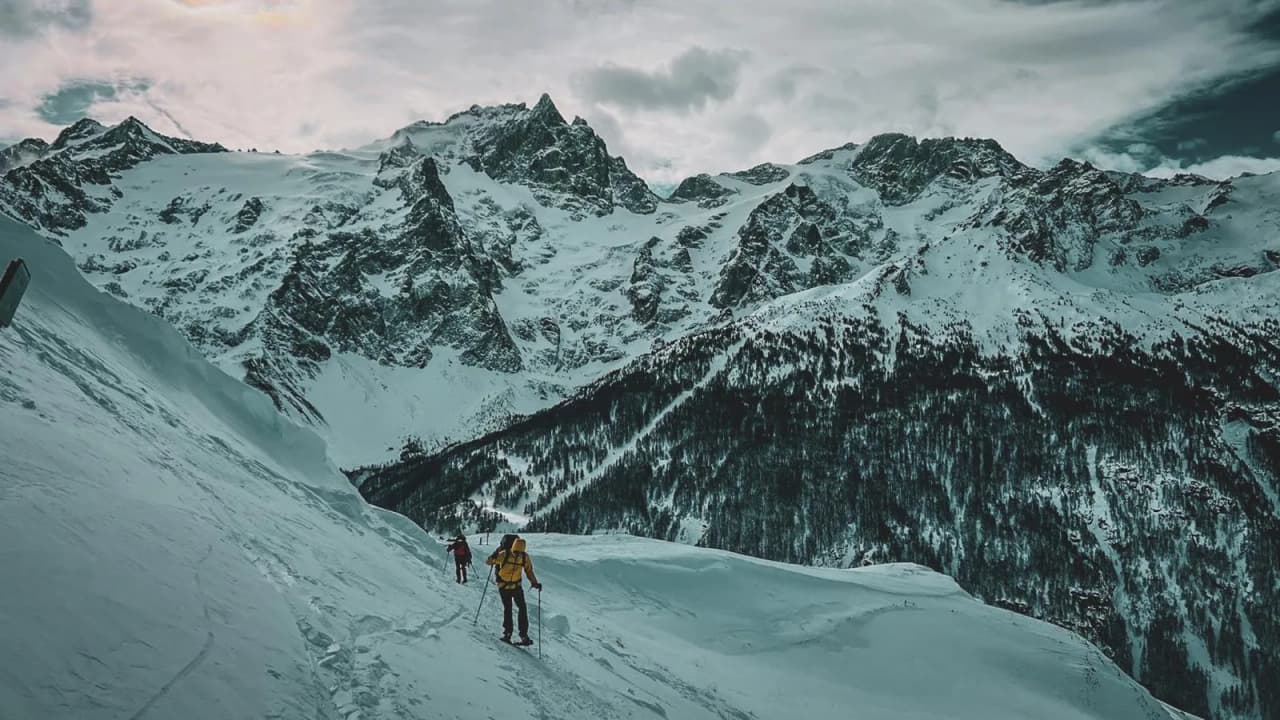 Een majestueus alpenlandschap met sneeuwschoenwandelaars op ongerepte sneeuw, met uitzicht op de Meije.