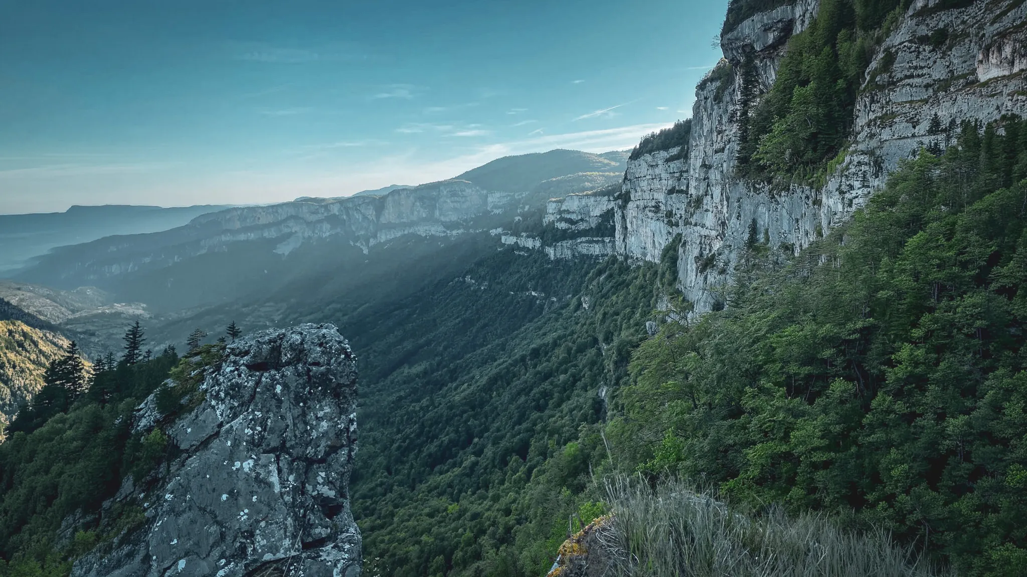 Een wandelaar die de berglandschappen van de Vercors verkent, tussen groene weiden en bergtoppen.