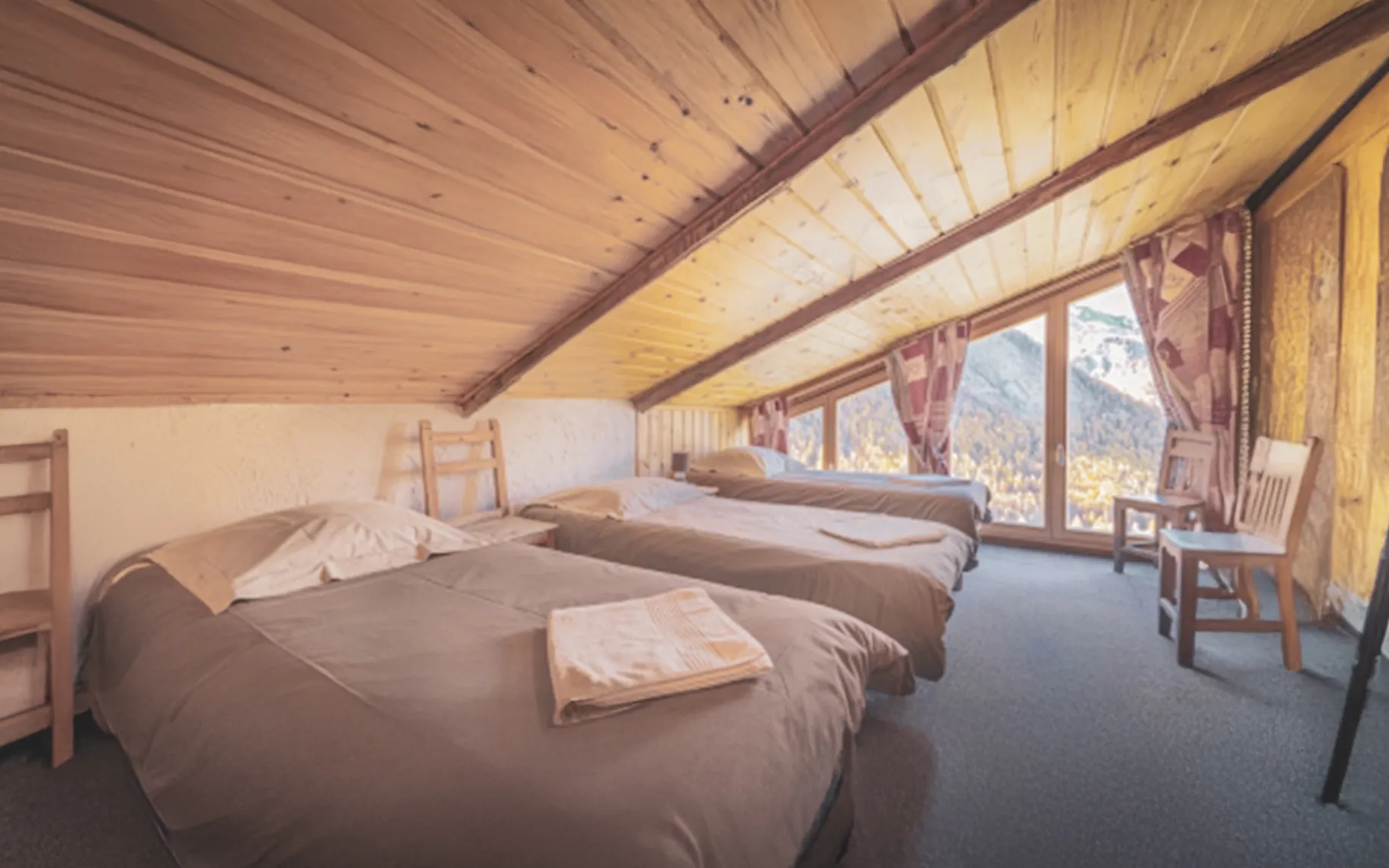 Comfortable rooms with wooden ceilings and panoramic views of the surrounding mountains.