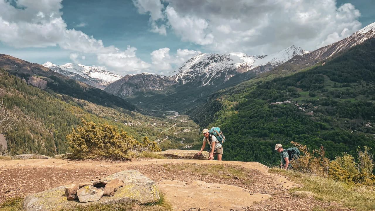 A spectacular view of the Écrins mountains, with floating clouds and snow-capped peaks. A breathtaking panorama!