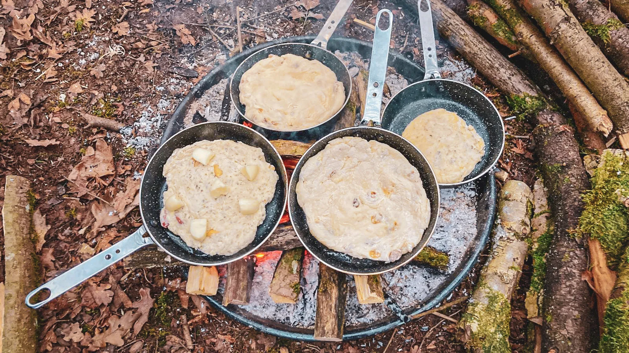 Des crêpes cuisent sur le feu, au cœur d'une forêt verdoyante de l'Ardenne belge.