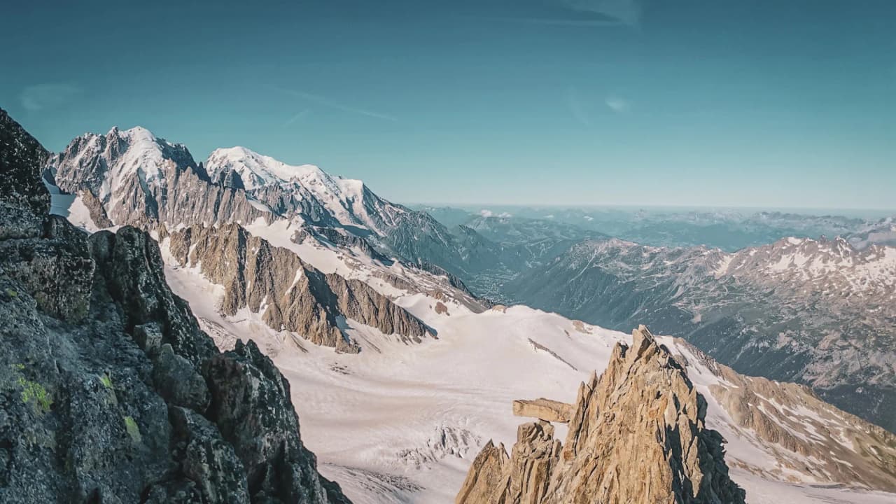 Panoramisch uitzicht op de majestueuze Mont Blanc bergen, tussen gletsjers en azuurblauwe luchten.