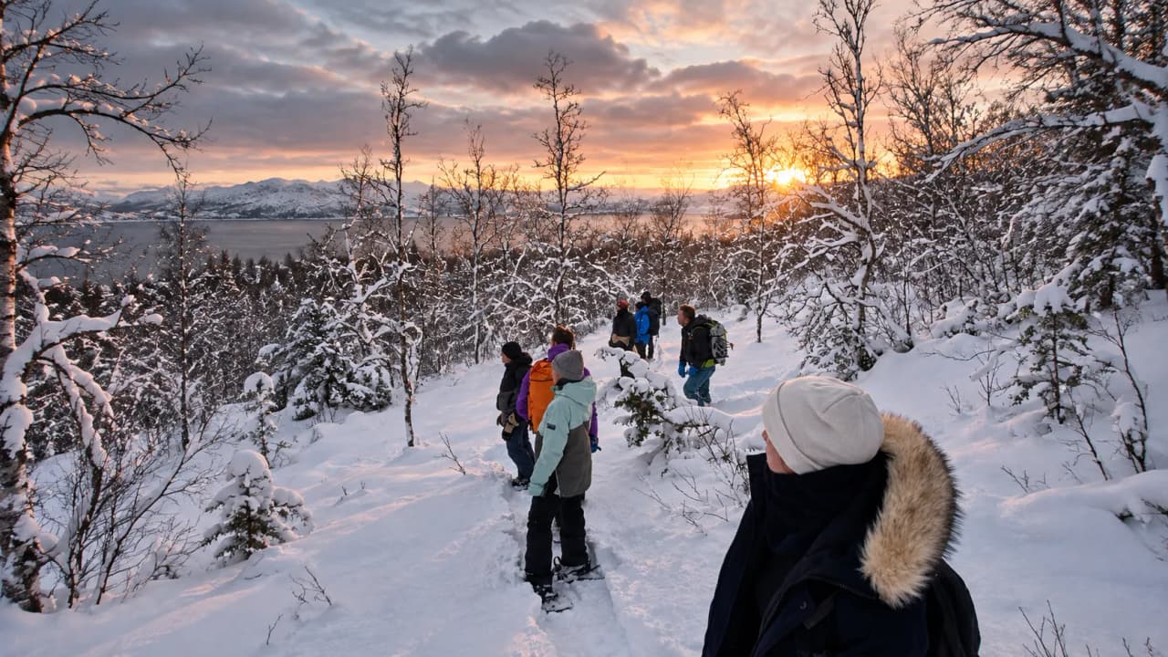 Groupe de randonneurs sous un coucher de soleil magique dans un paysage enneigé des Lofoten.