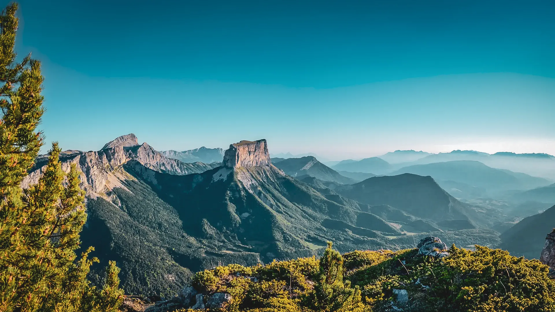 Panorama spectaculaire des Hauts Plateaux du Vercors, entre montagnes majestueuses et ciel bleu.
