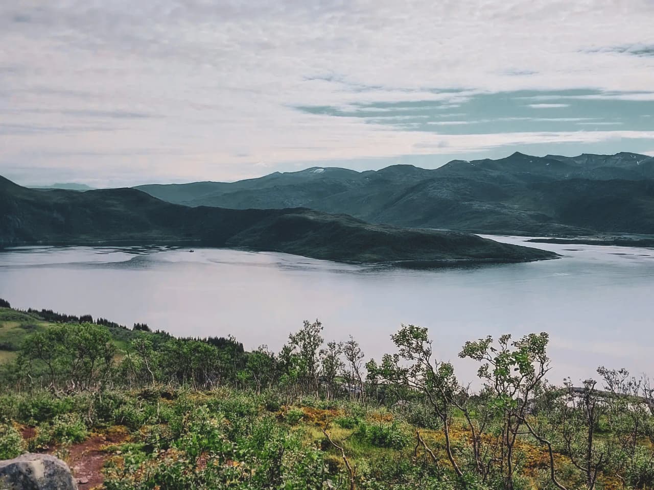 Rustgevend panoramisch uitzicht op het eiland Senja, sprankelende meren en majestueuze bergen.