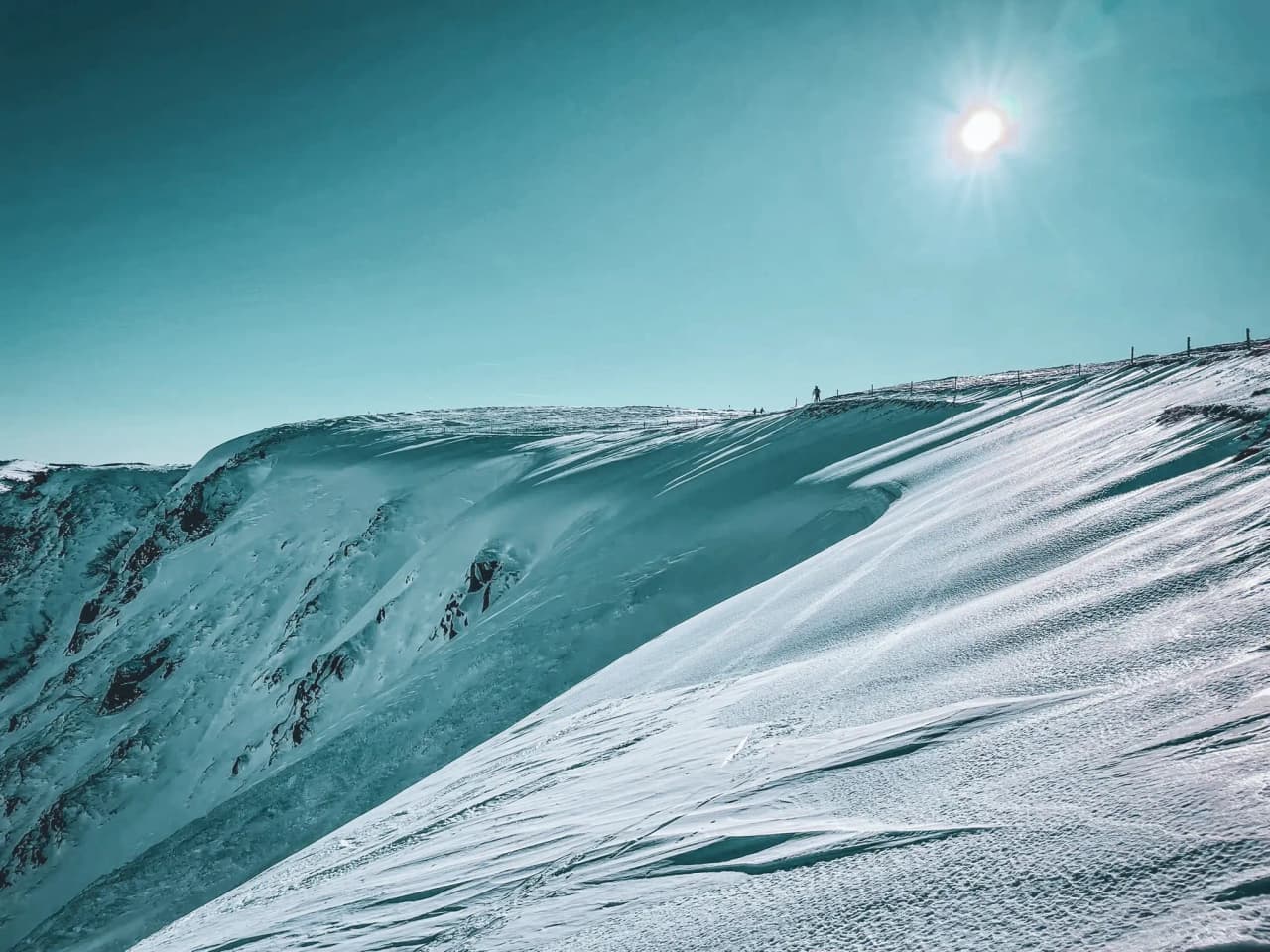 Een besneeuwd Vogezenlandschap onder een blauwe hemel, dat uitnodigt tot een sneeuwschoenavontuur.