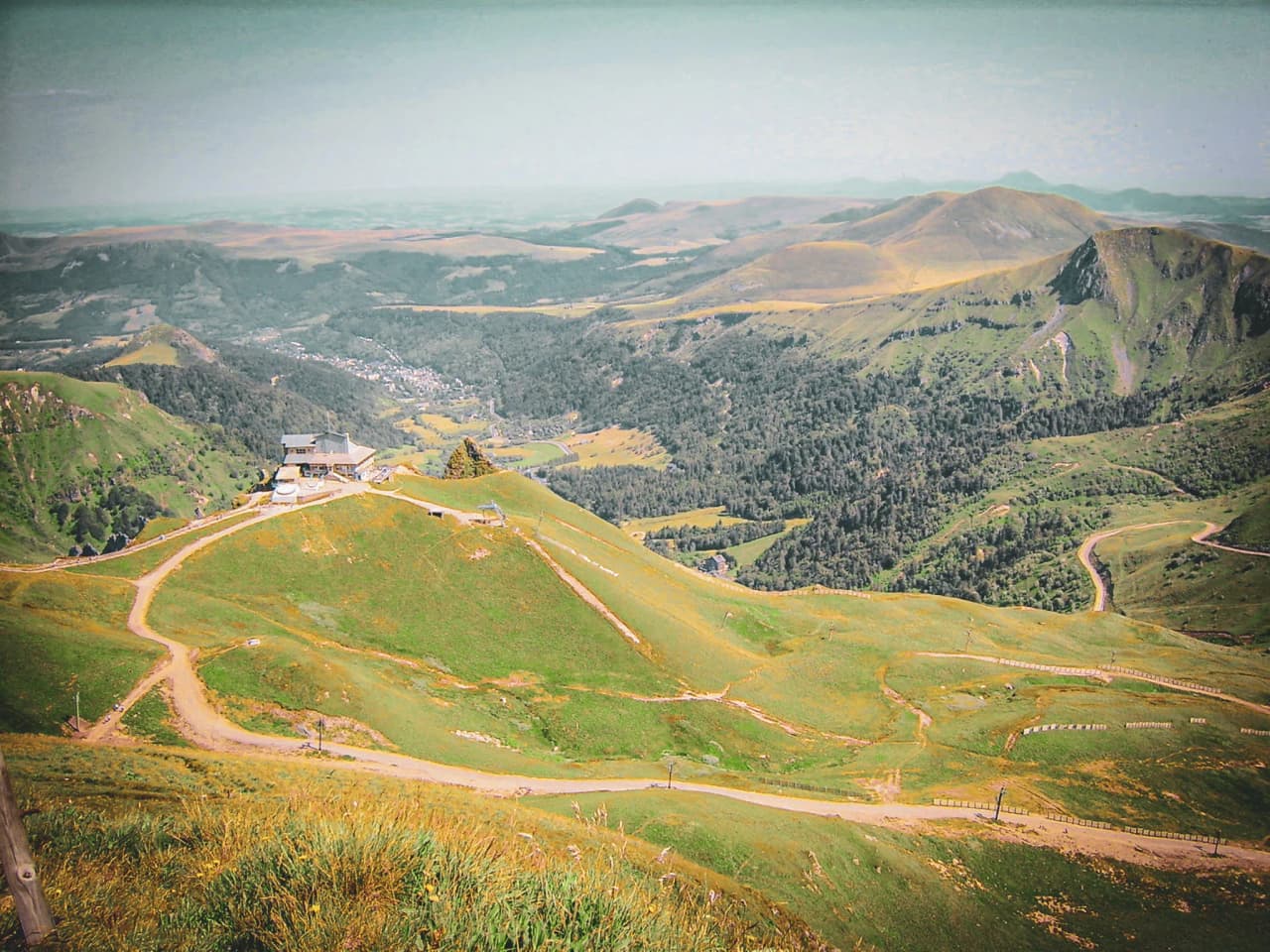 Een groen panorama van het Centraal Massief, met vulkaanruggen en kronkelende paden. De ontsnapping van de natuur!