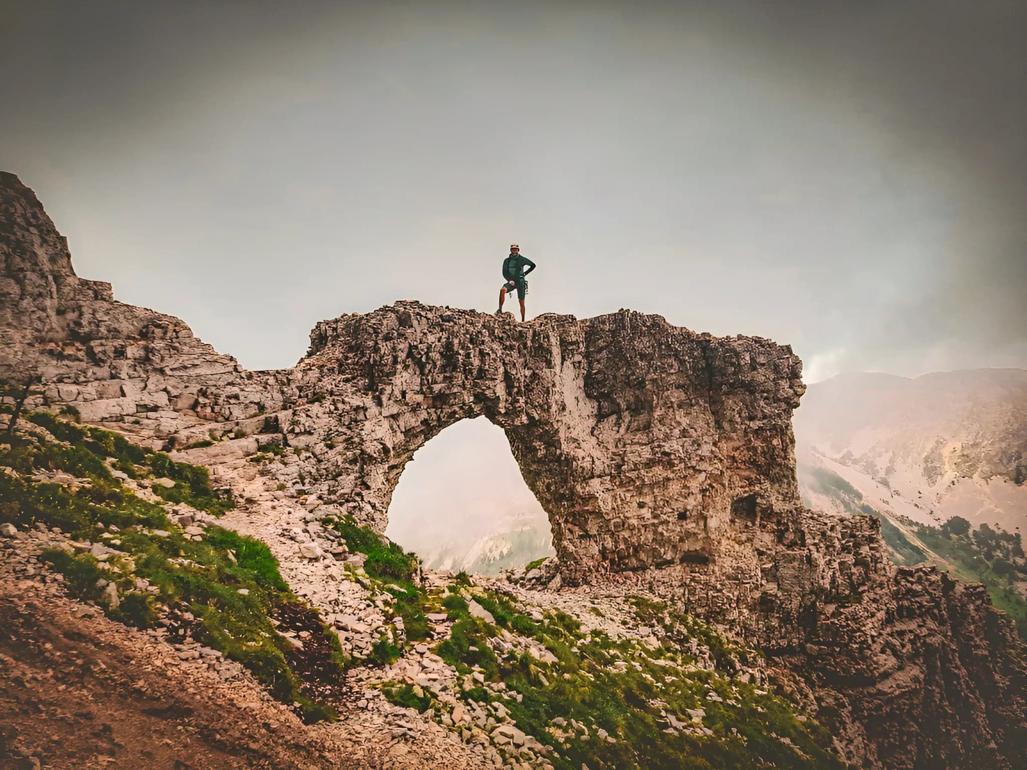 Een klimmer staat op een majestueuze rots en biedt een panoramisch uitzicht op de Mont Aiguille.