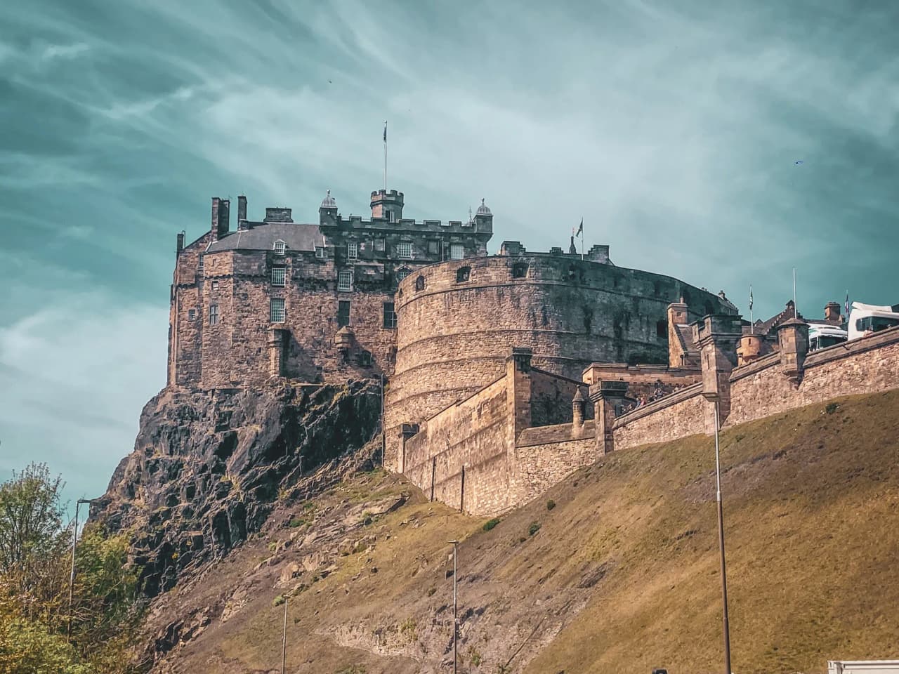 Château majestueux sur un piton rocheux, avec un ciel lumineux en toile de fond, invitant à l'aventure.