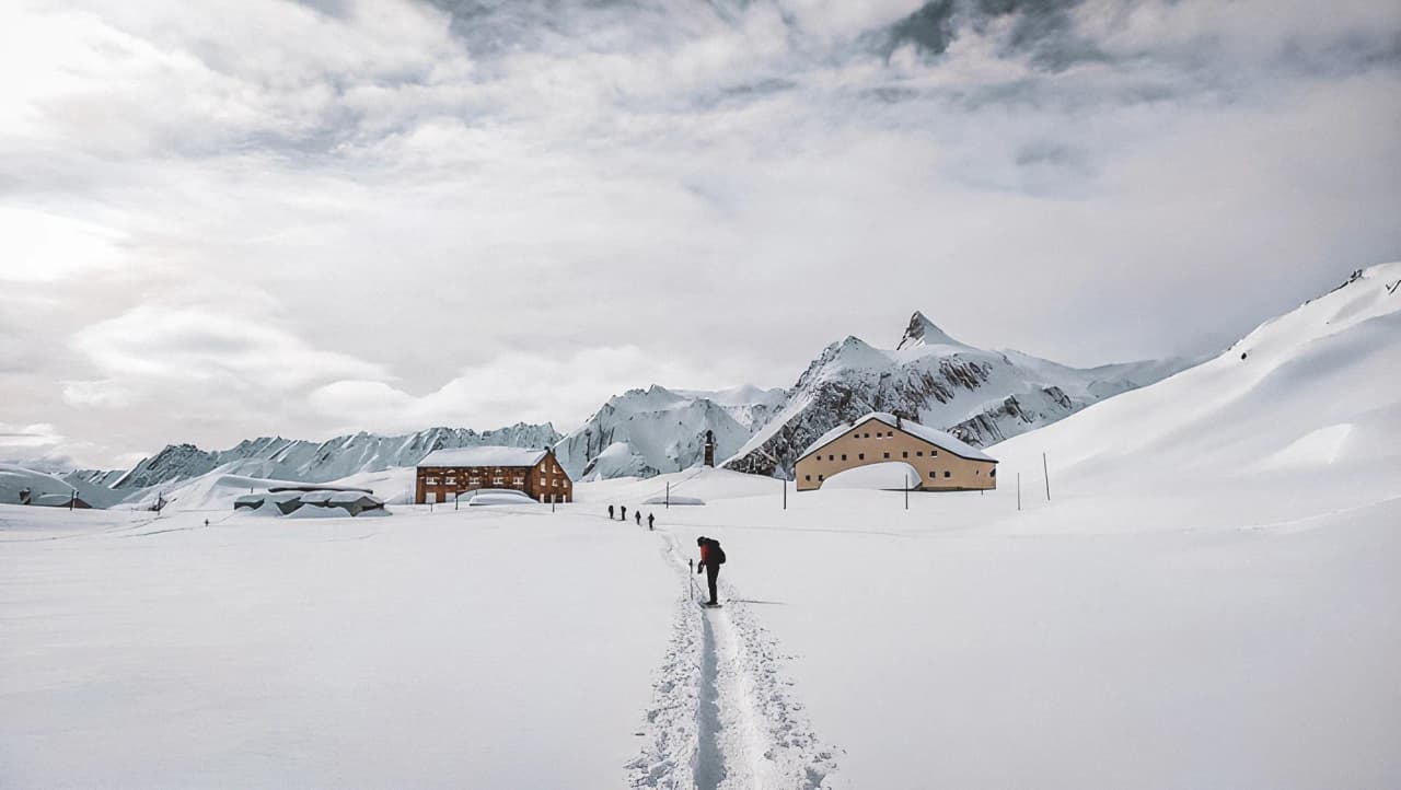Piste enneigée menant à des refuges pittoresques sous les sommets des Alpes. Évasion assurée !