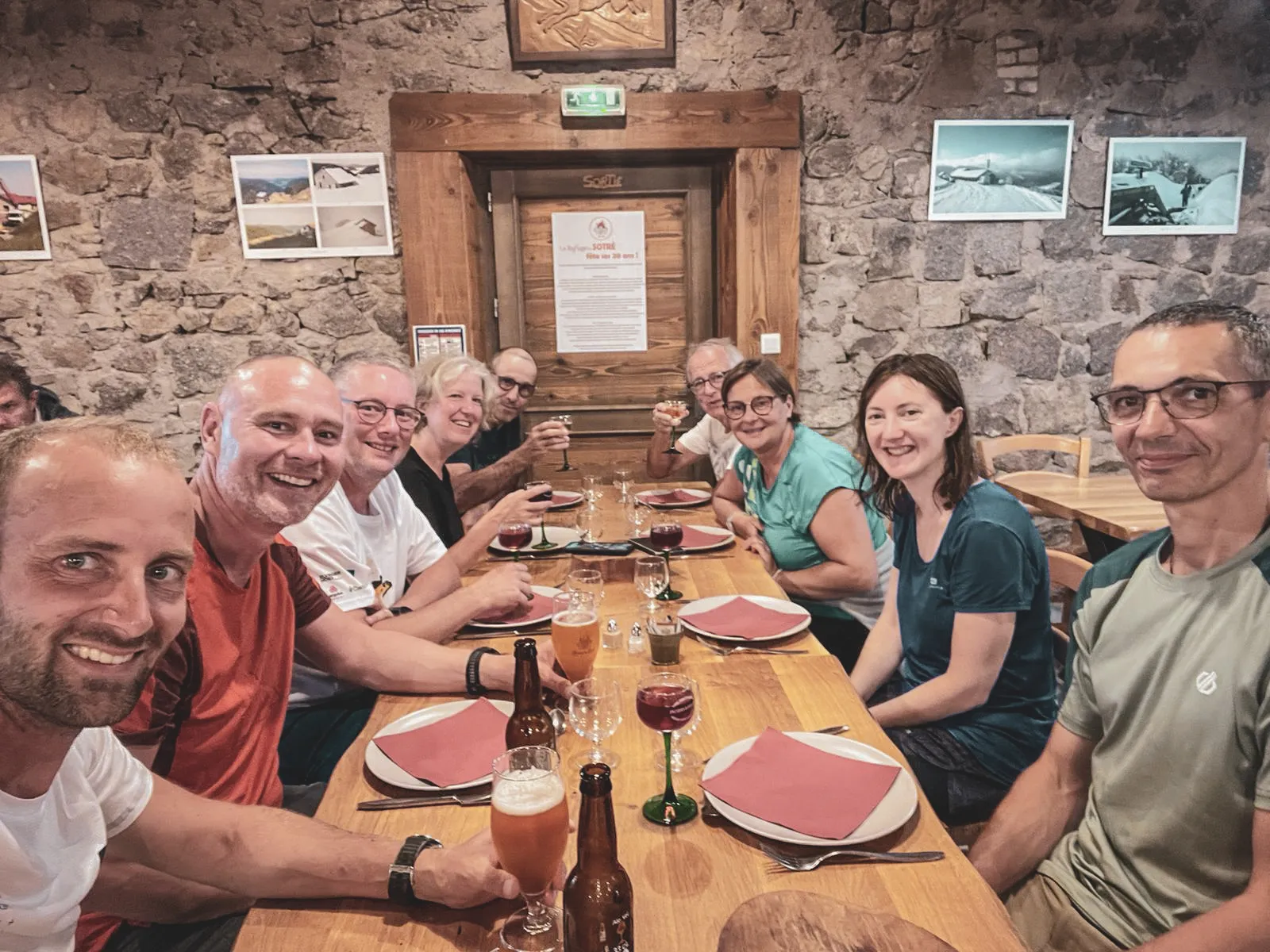 A cheerful group shares a mountain meal in a cosy Mountain hut in the Vosges.