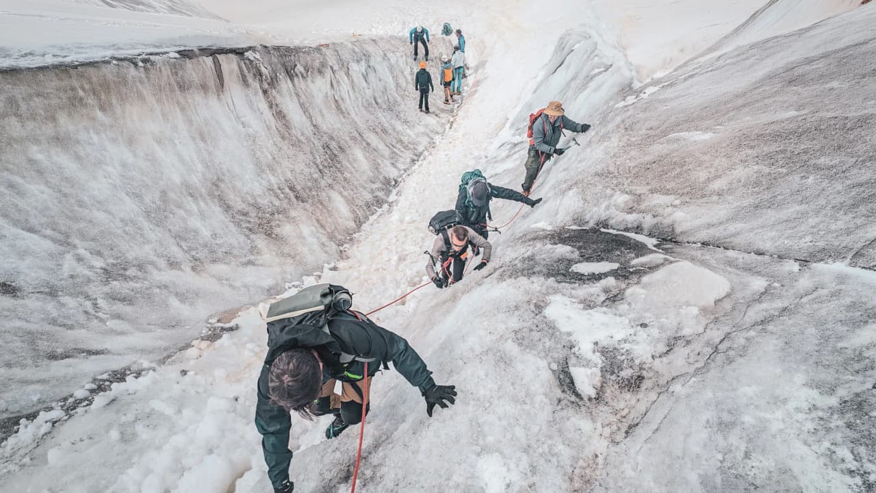 A group of mountaineers are climbing an icy face, taking on Mont Blanc in the heart of the Alps.
