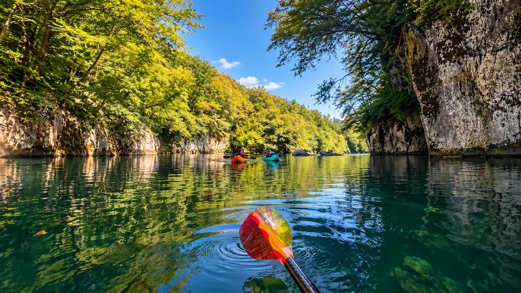 Deux kayakistes glissent sur des eaux émeraude, entourés de falaises verdoyantes en Slovénie.