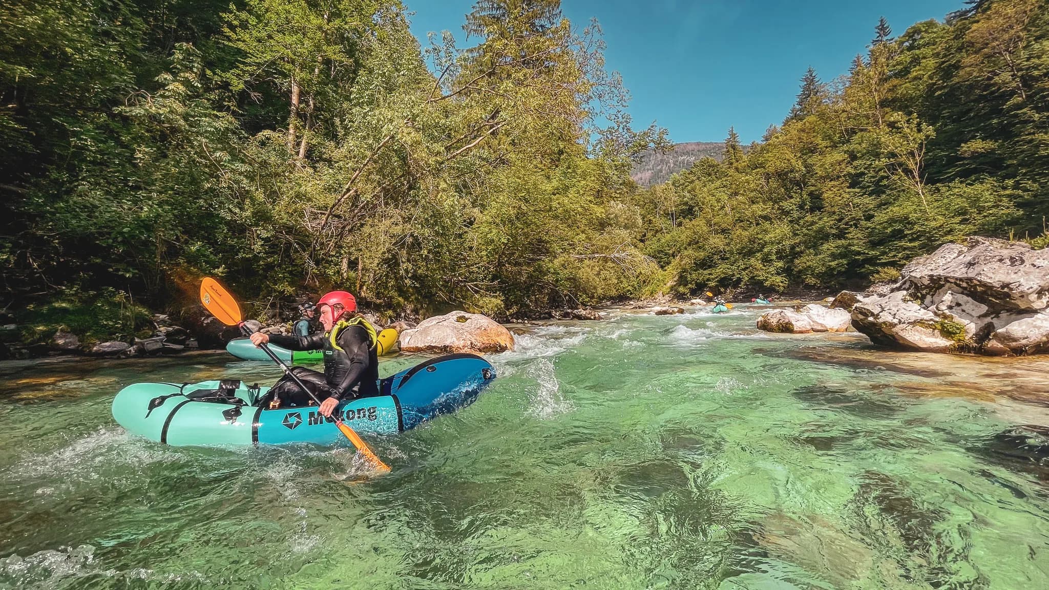 Pagaie en main, aventurier sur une rivière turquoise, entouré de verdure alpine en Slovénie.