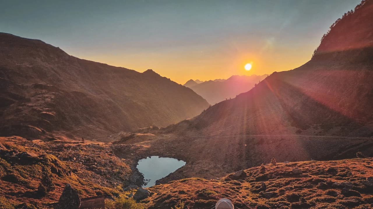 Zonsondergang boven de Pyreneeën, een vredige weerspiegeling in een bergmeer.