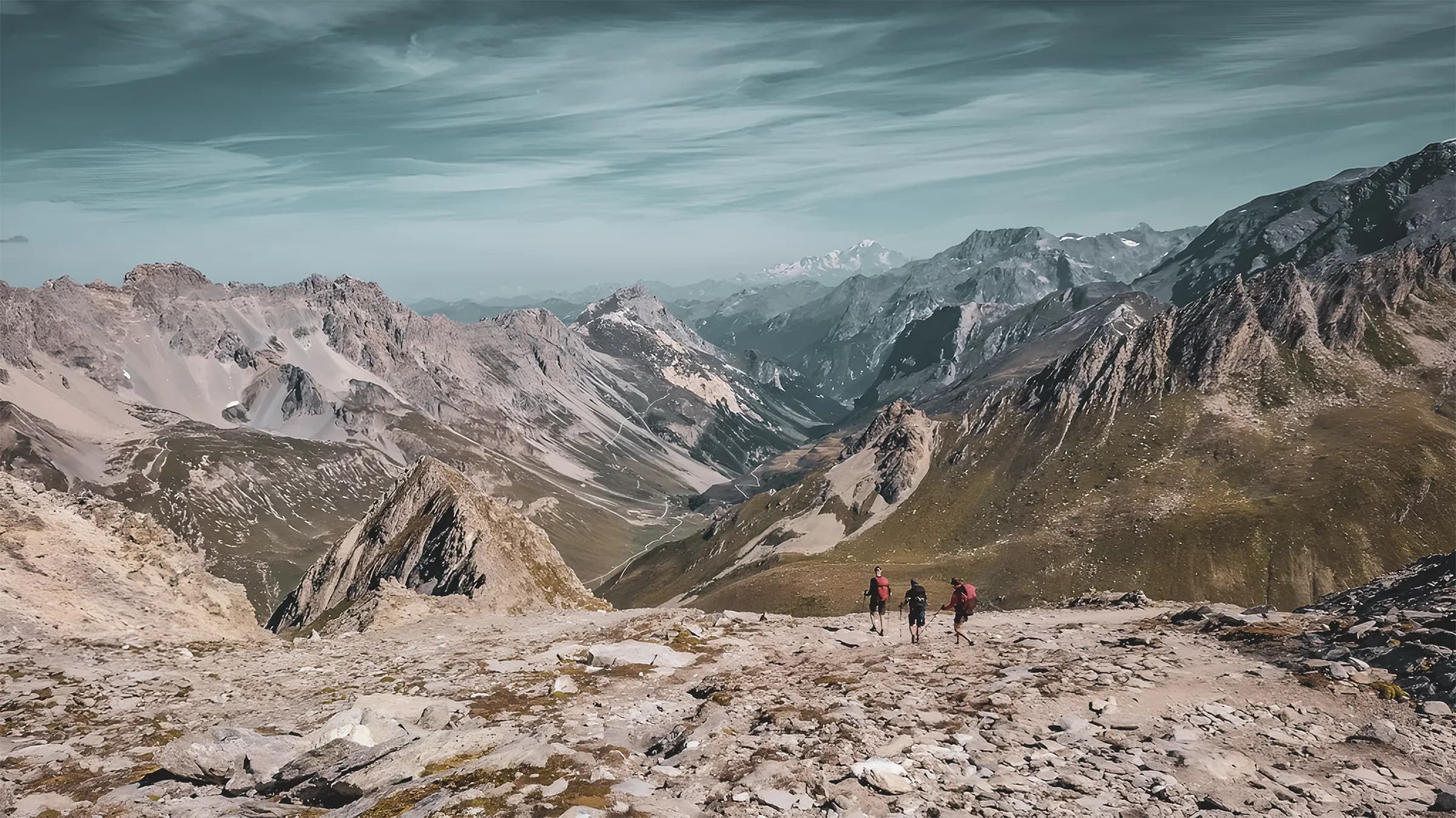 Hikers on a mountain trail, with breathtaking Alpine scenery.