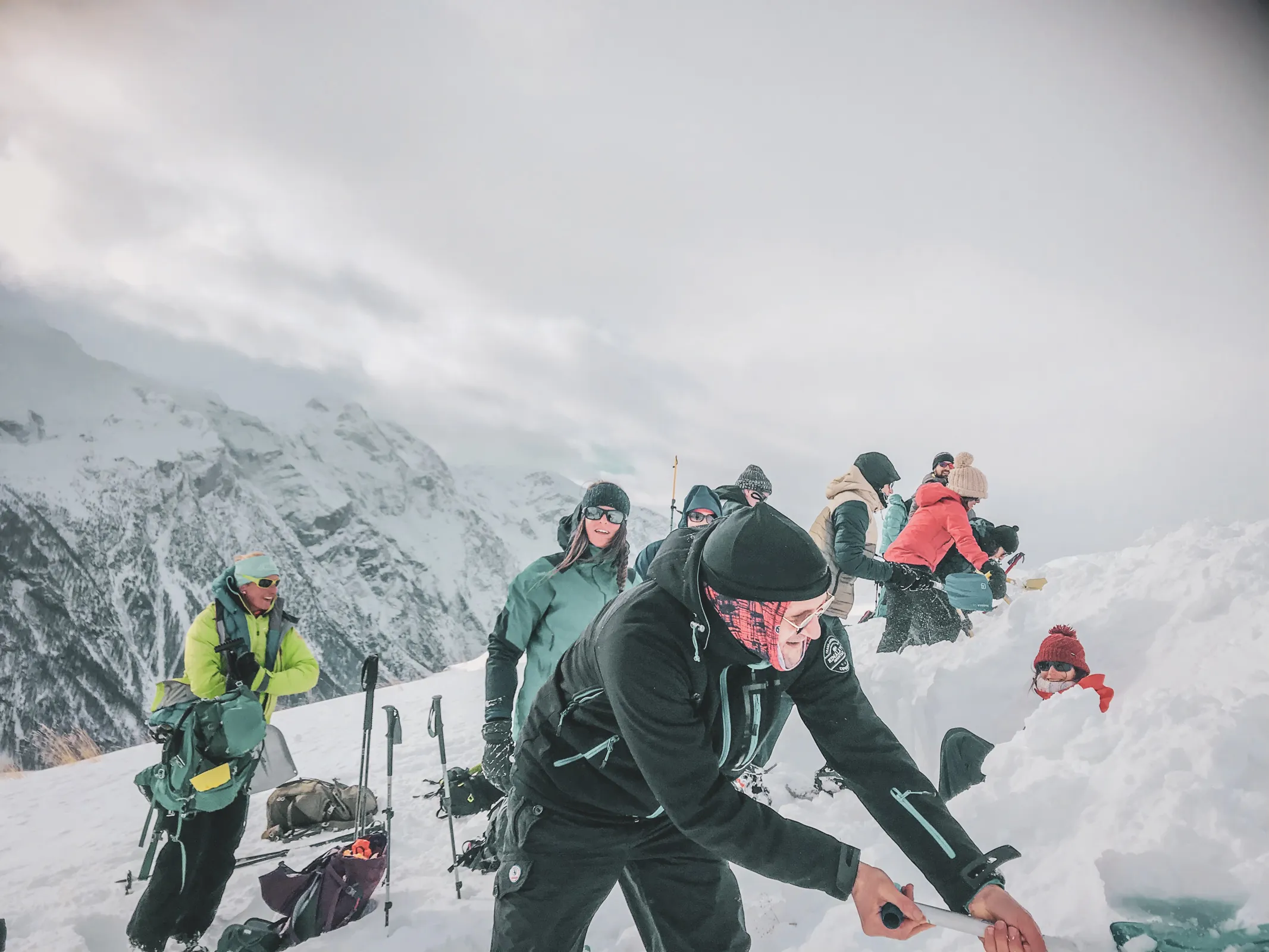 Groupe d'aventuriers en raquettes, explorant un paysage enneigé face à des glaciers majestueux.