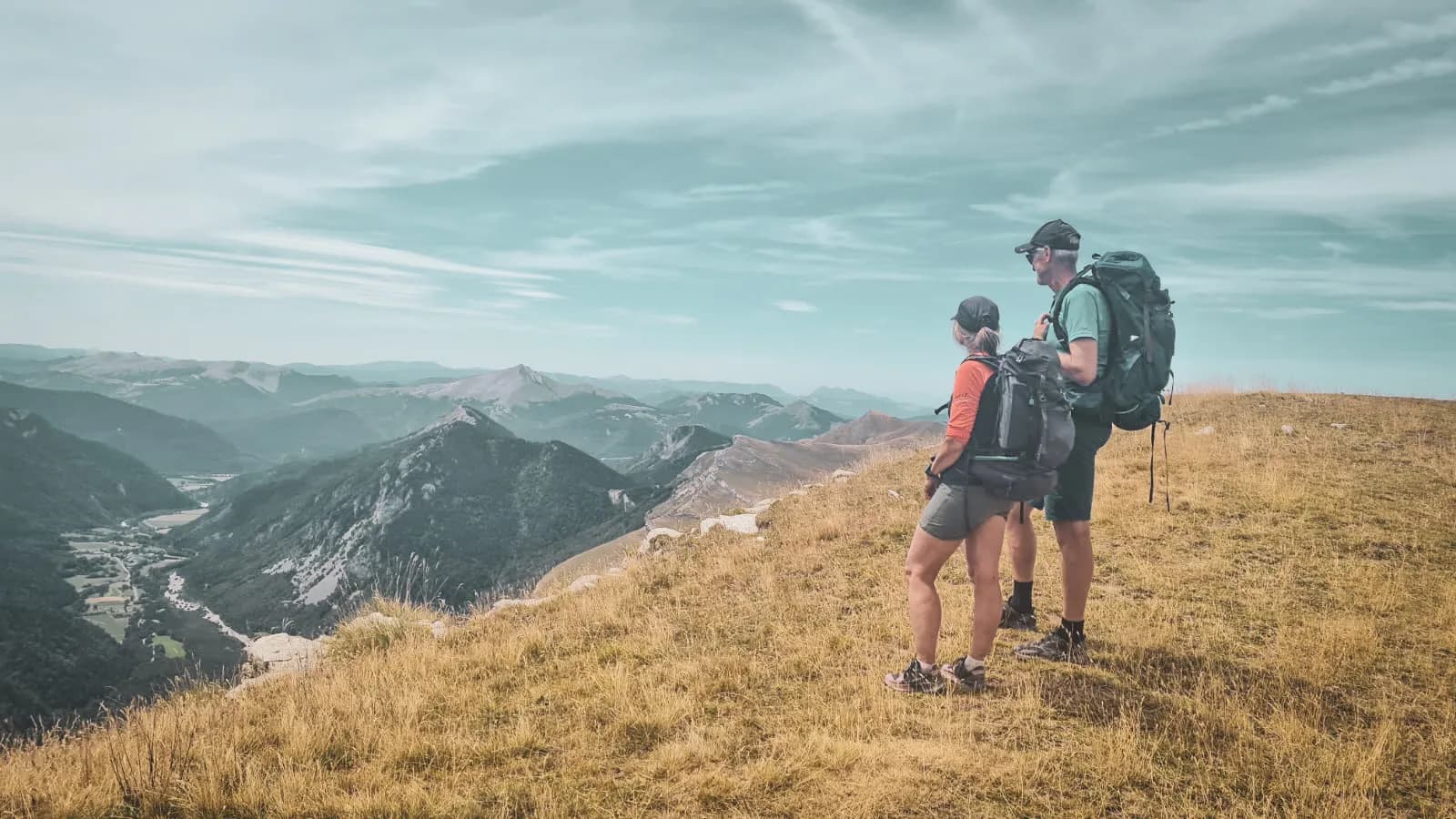 two adventurers admire majestic peaks and enchanting landscapes.