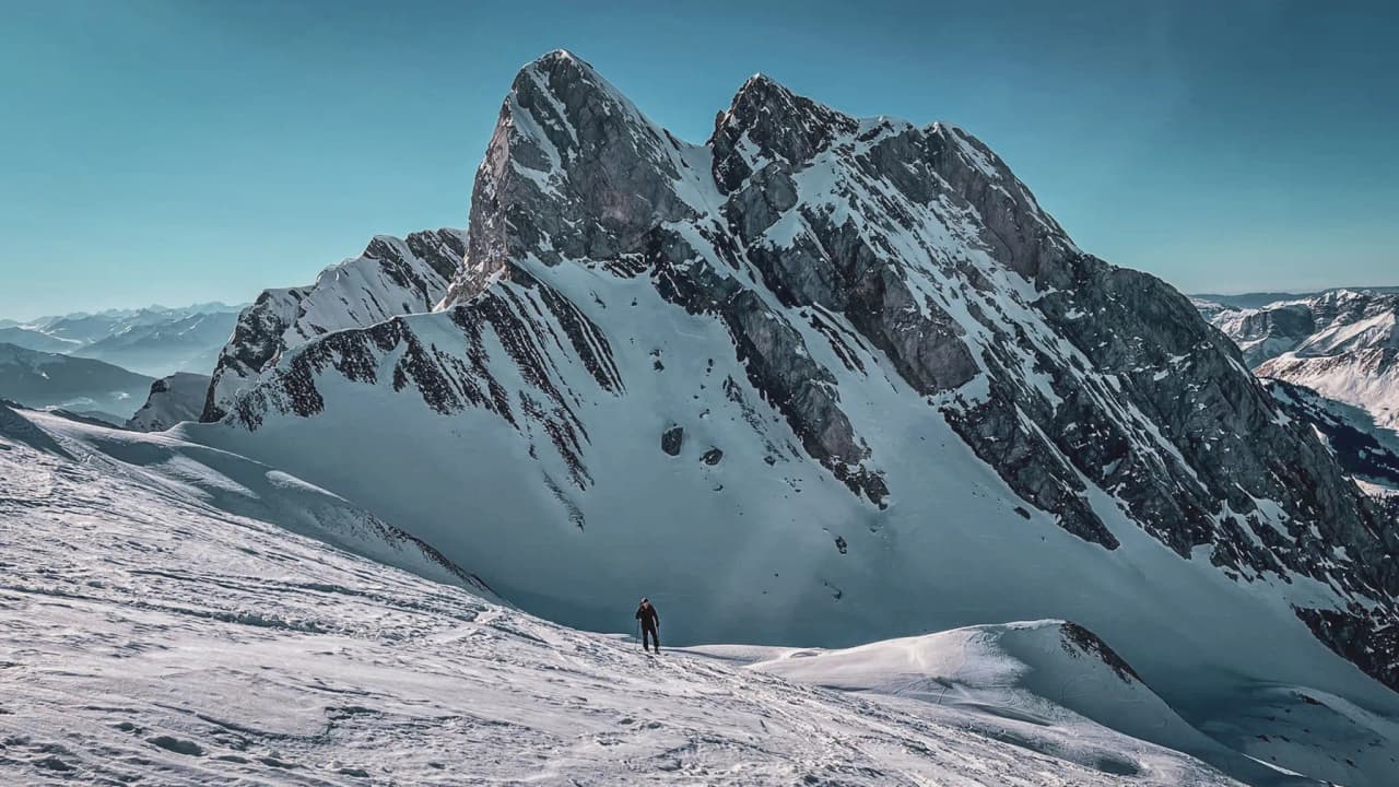 A majestic peak in the Aravis, a lone skier on the glistening snow – an invitation to adventure.