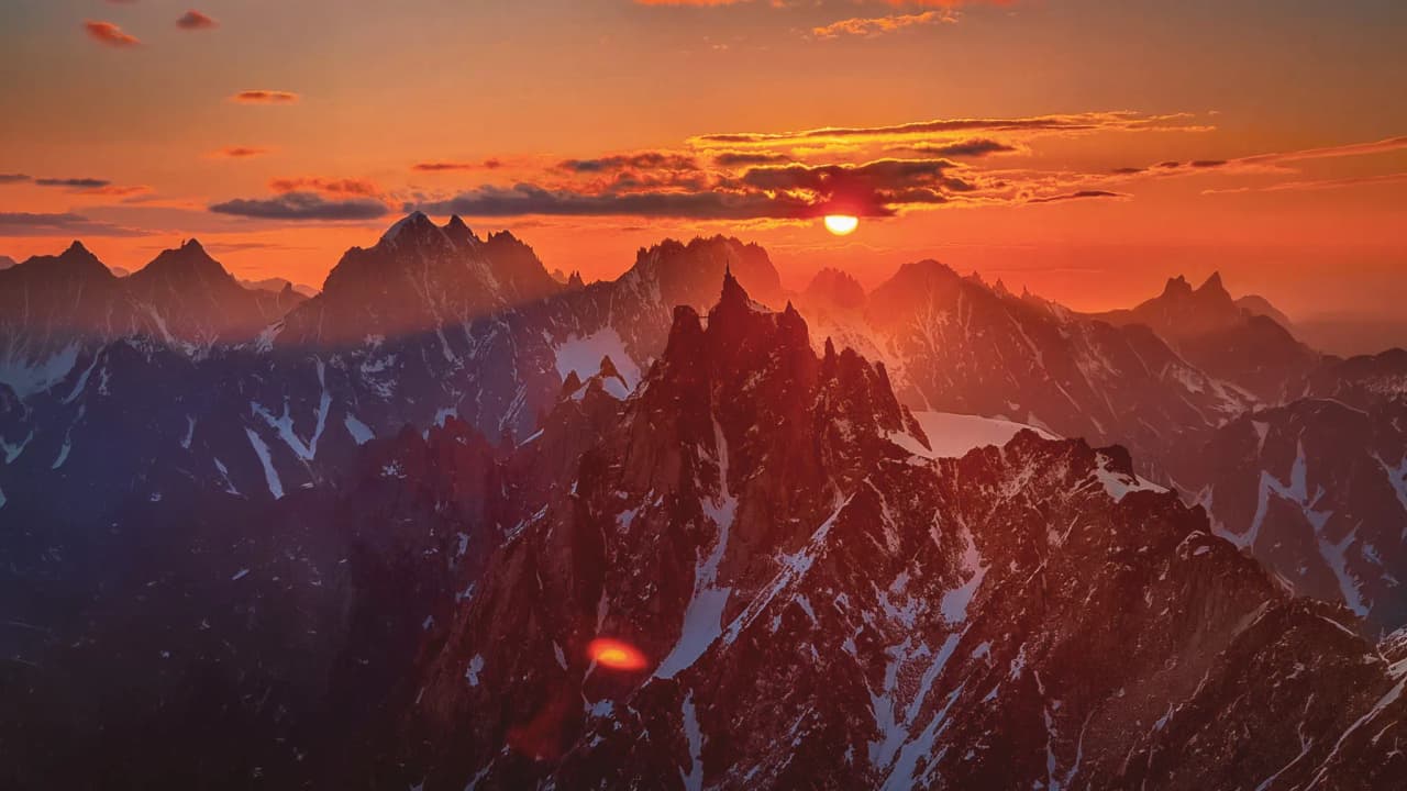 A majestic sunset over the snow-capped peaks of the Alps – an invitation to adventure.