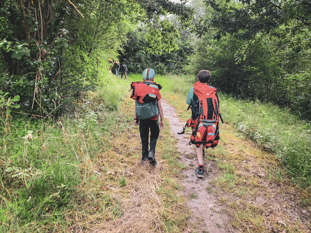 Two young adventurers are walking along a green path, ready to explore the Belgian countryside.
