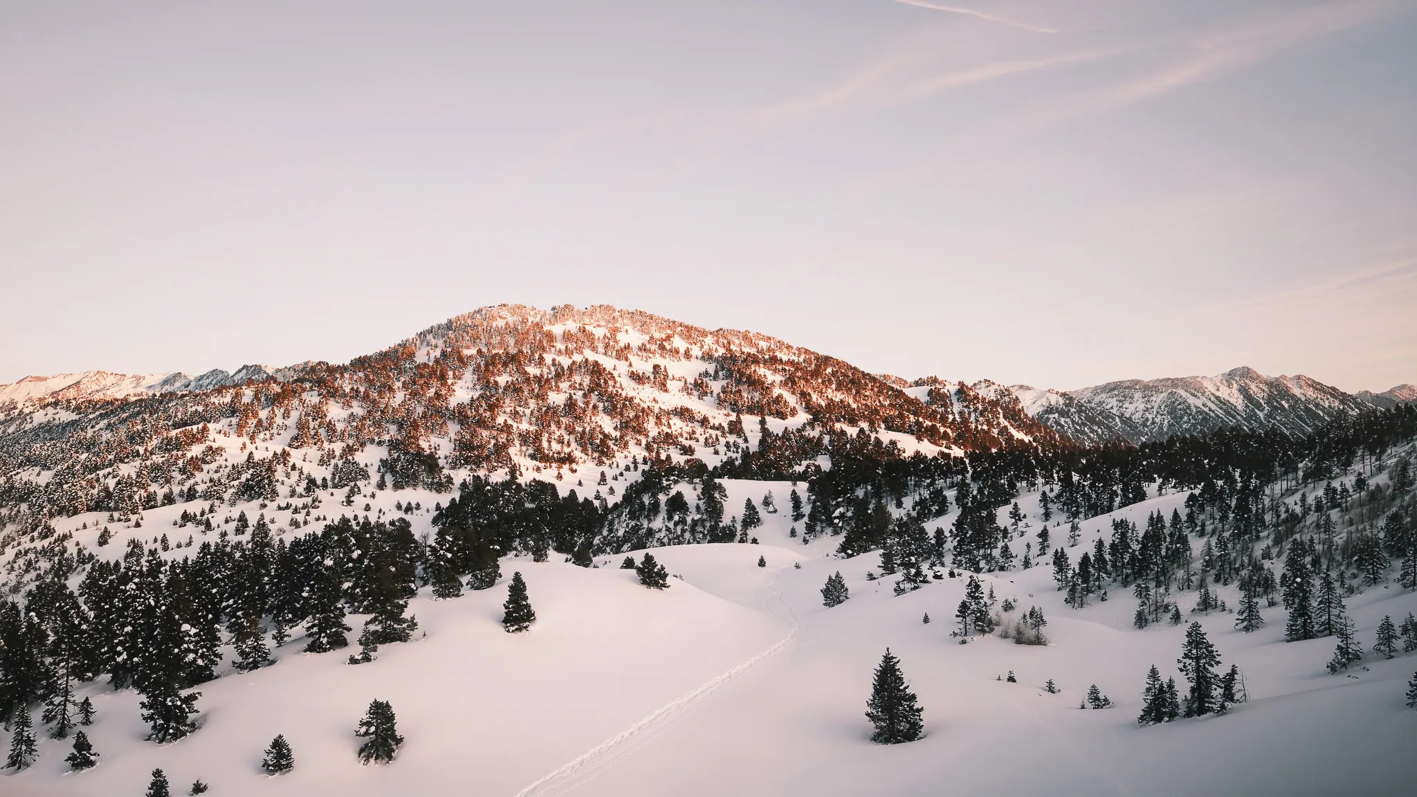 Paysage enneigé du Vercors avec montagnes majestueuses et sapins, invitation à l'aventure en raquettes.