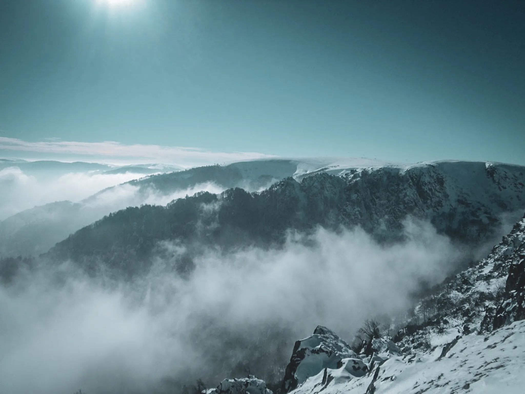 Majestic winter scenery, snow-capped mountains and mist in the Vosges Natural Park.