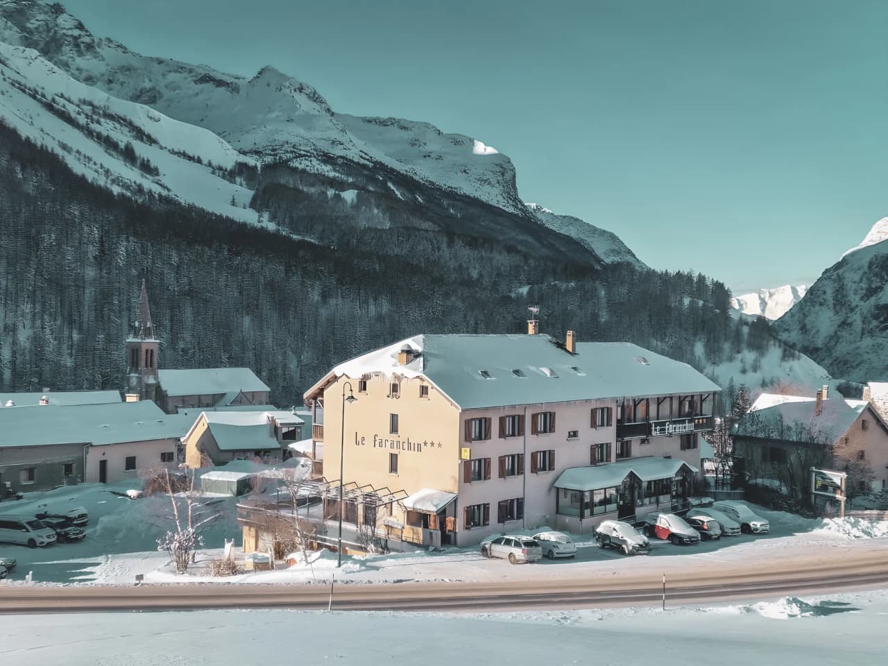 Charmant refuge alpin sous la neige, entouré de montagnes majestueuses, invitant à l'aventure.