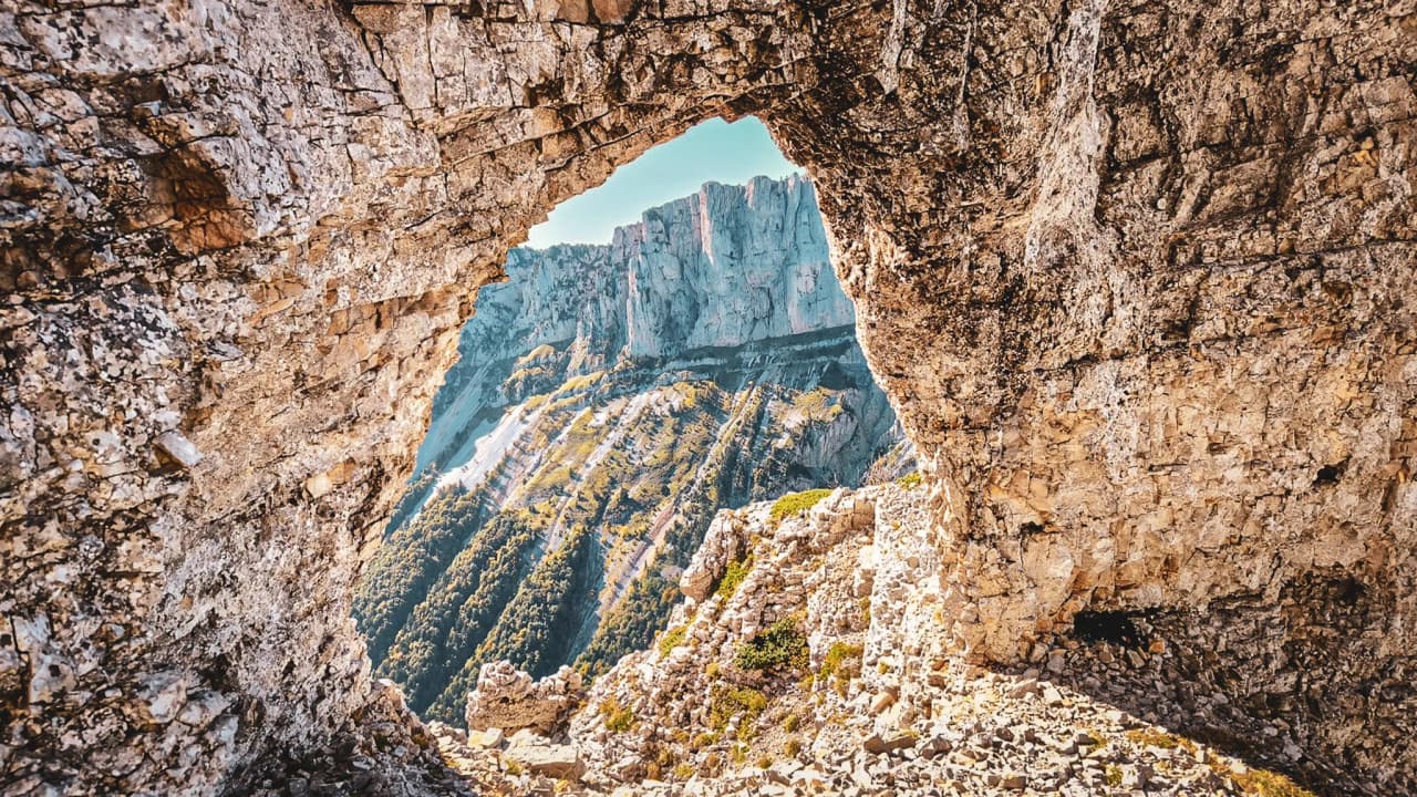 Spectaculair uitzicht op de Mont Aiguille door een rotsachtige opening, een uitnodiging tot avontuur.