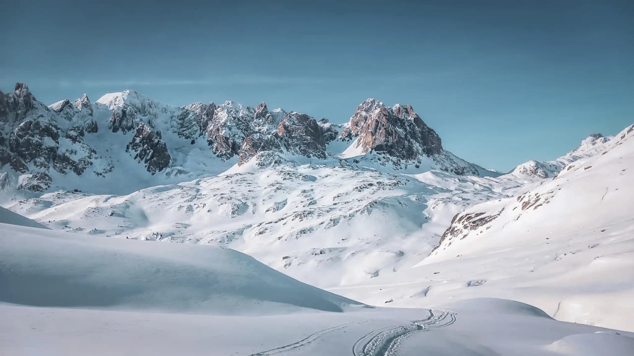 A vast snow-covered landscape with majestic mountains, inviting you to embark on a winter adventure.
